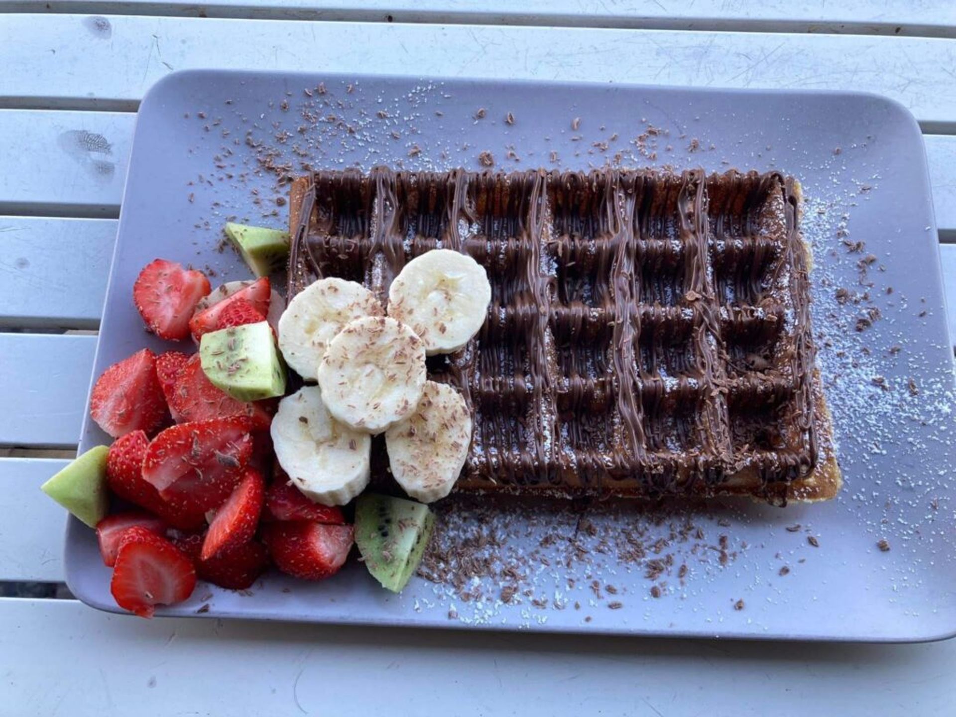 A chocolate waffle with fruit and Nutella.