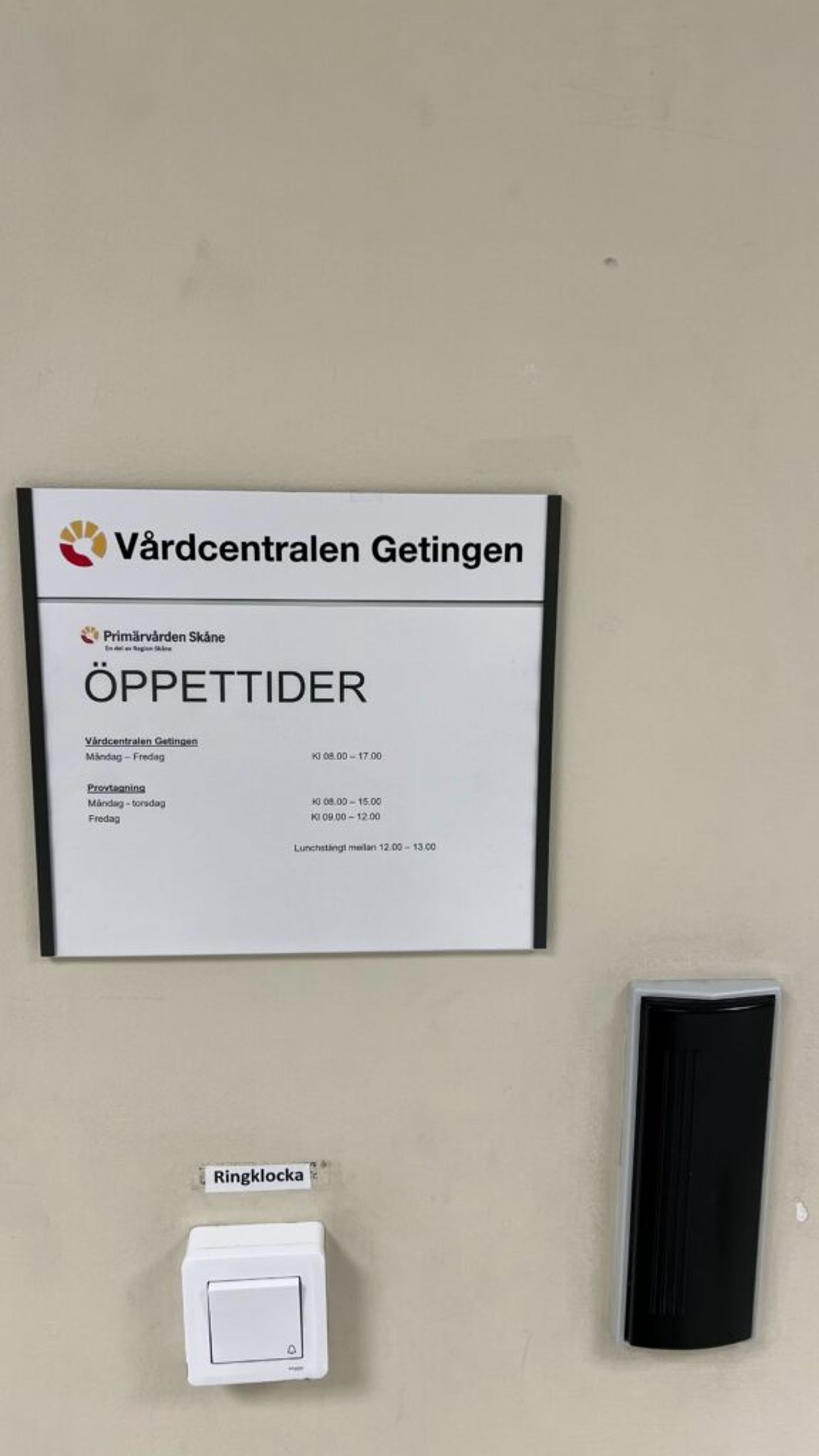 A sign displaying the hospital's opening hours at Primärvården Skåne.