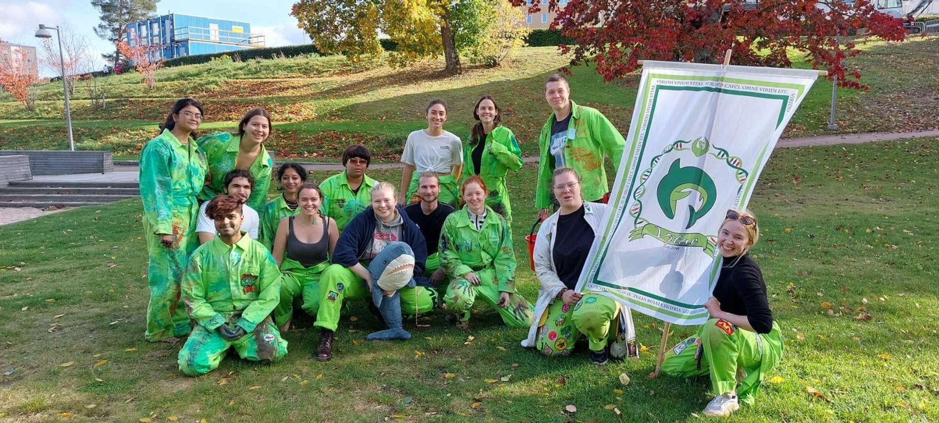 Students in matching green overalls enjoying a day at the park.