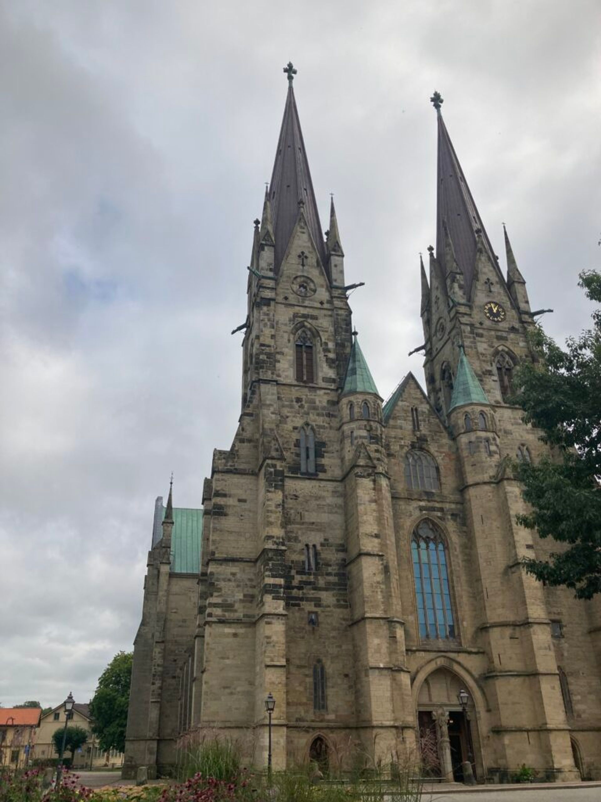 A large cathedral with tall spires under a cloudy sky.