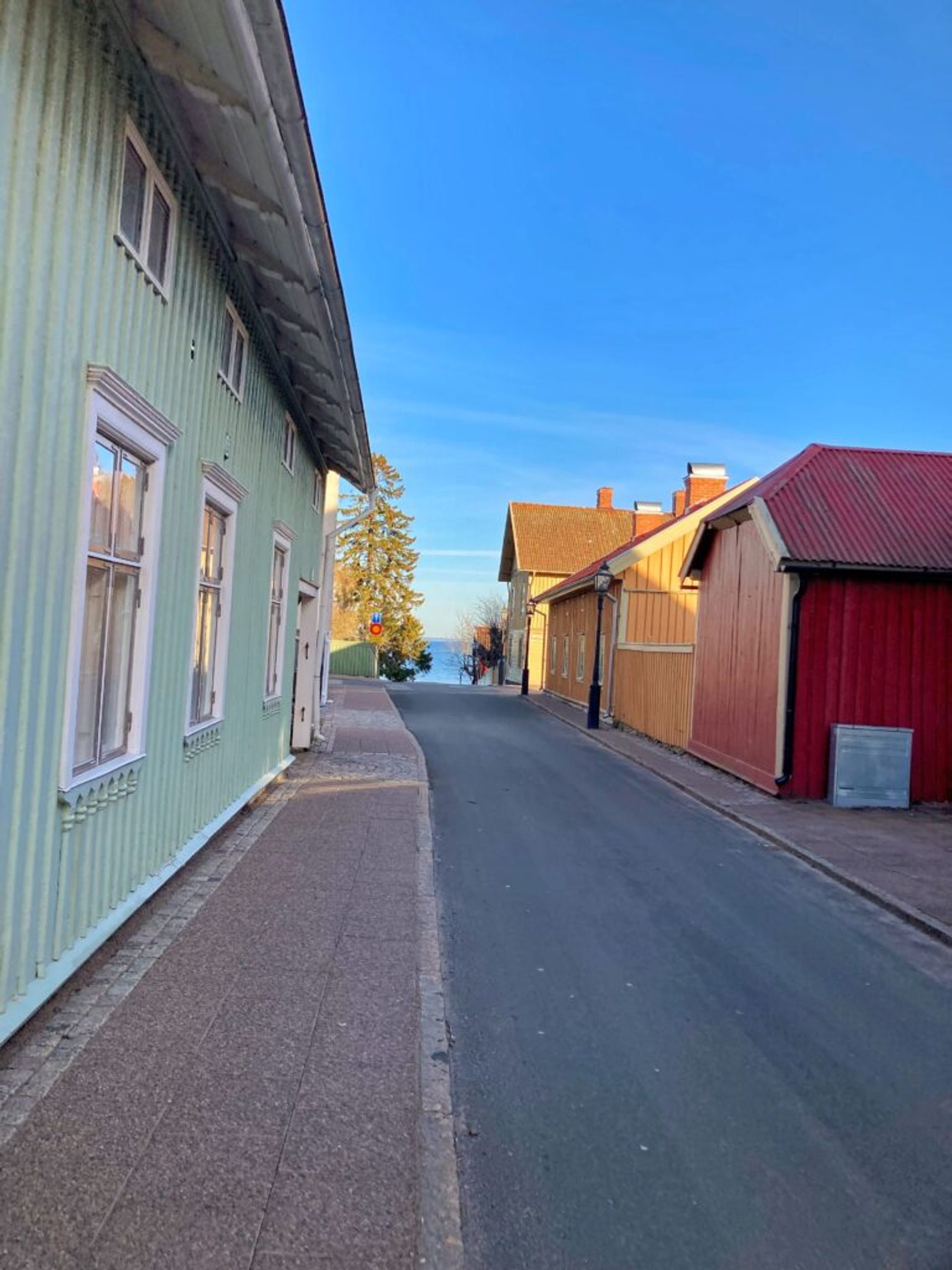 An empty street flanked by old Swedish houses.