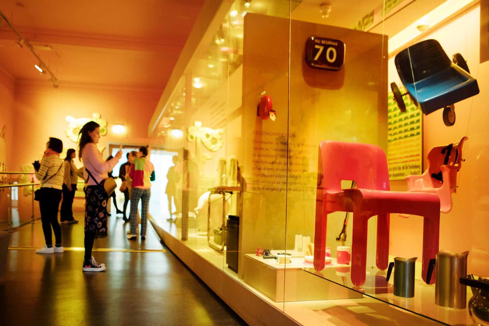 Visitors explore a museum exhibition showcasing design products.