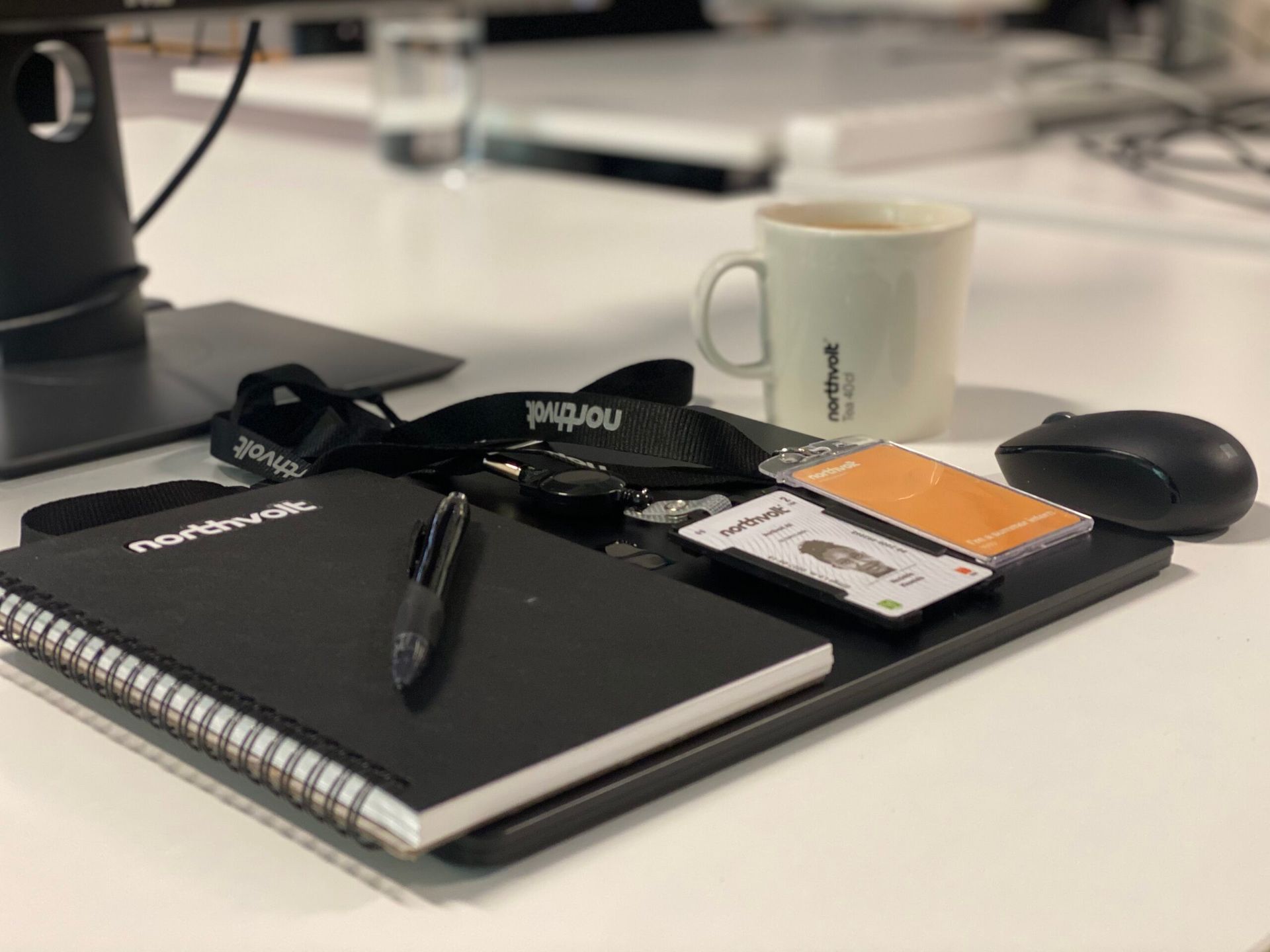 A desk with a notebook and access cards.