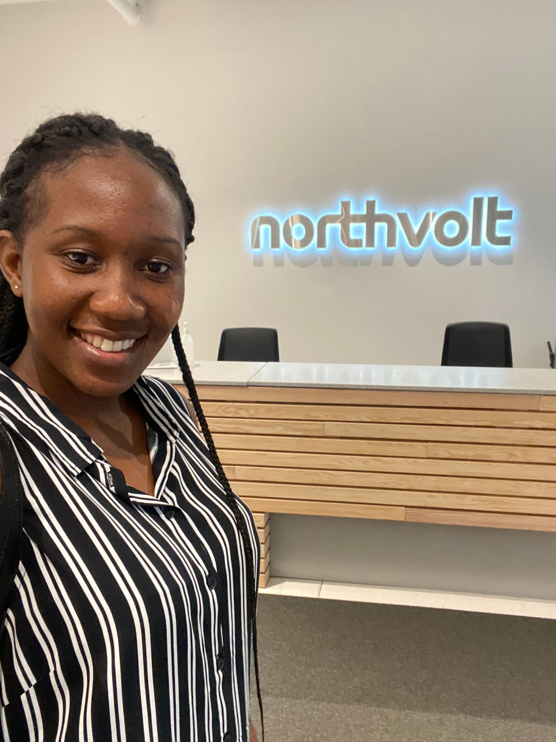 A woman standing in front of the Northvolt reception desk.