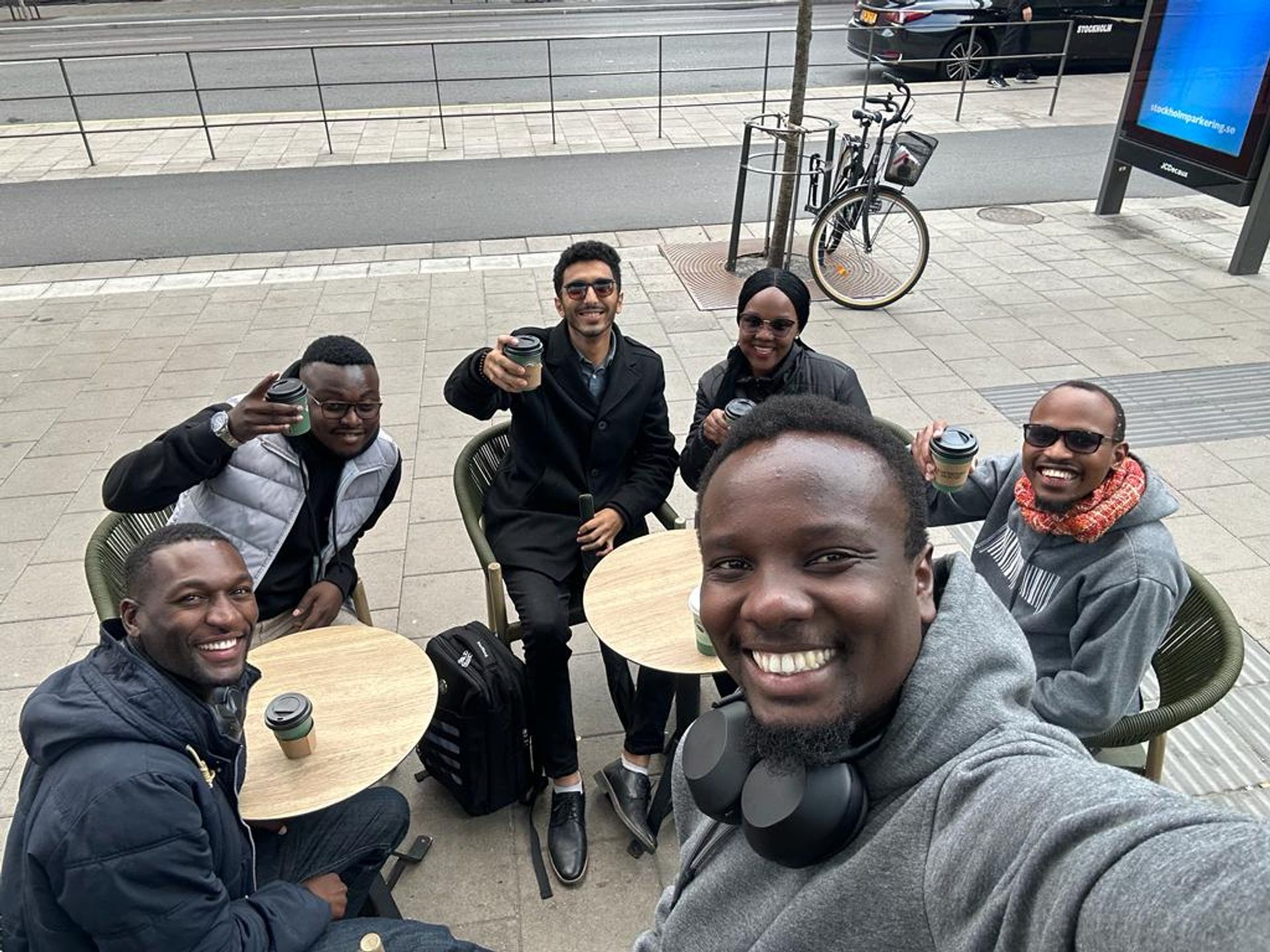 A group selfie of people smiling as they enjoy a morning coffee in Stockholm.