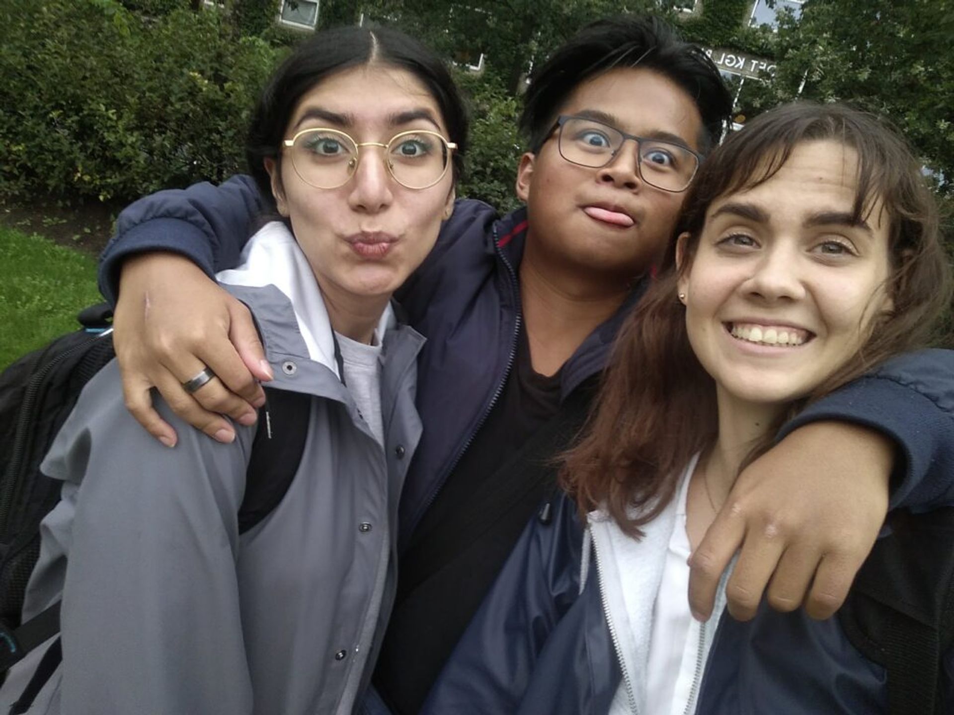 Three friends smiling in a cheerful selfie.