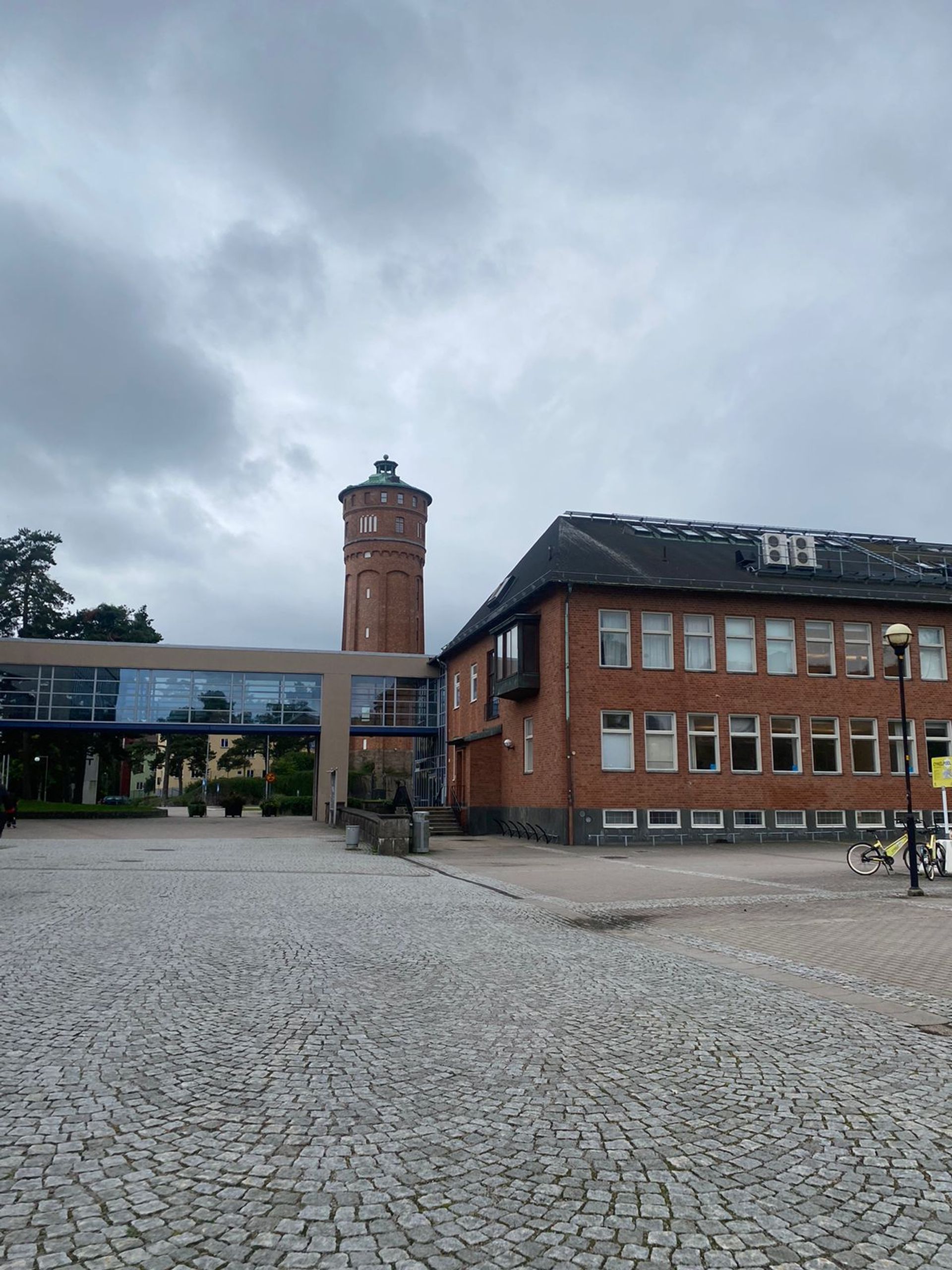 University West, with a brick tower overlooking a cobbled courtyard.