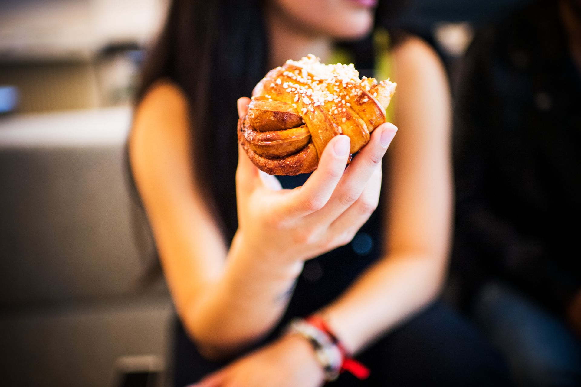 A close-up of a person holding a Swedish cinnamon bun.