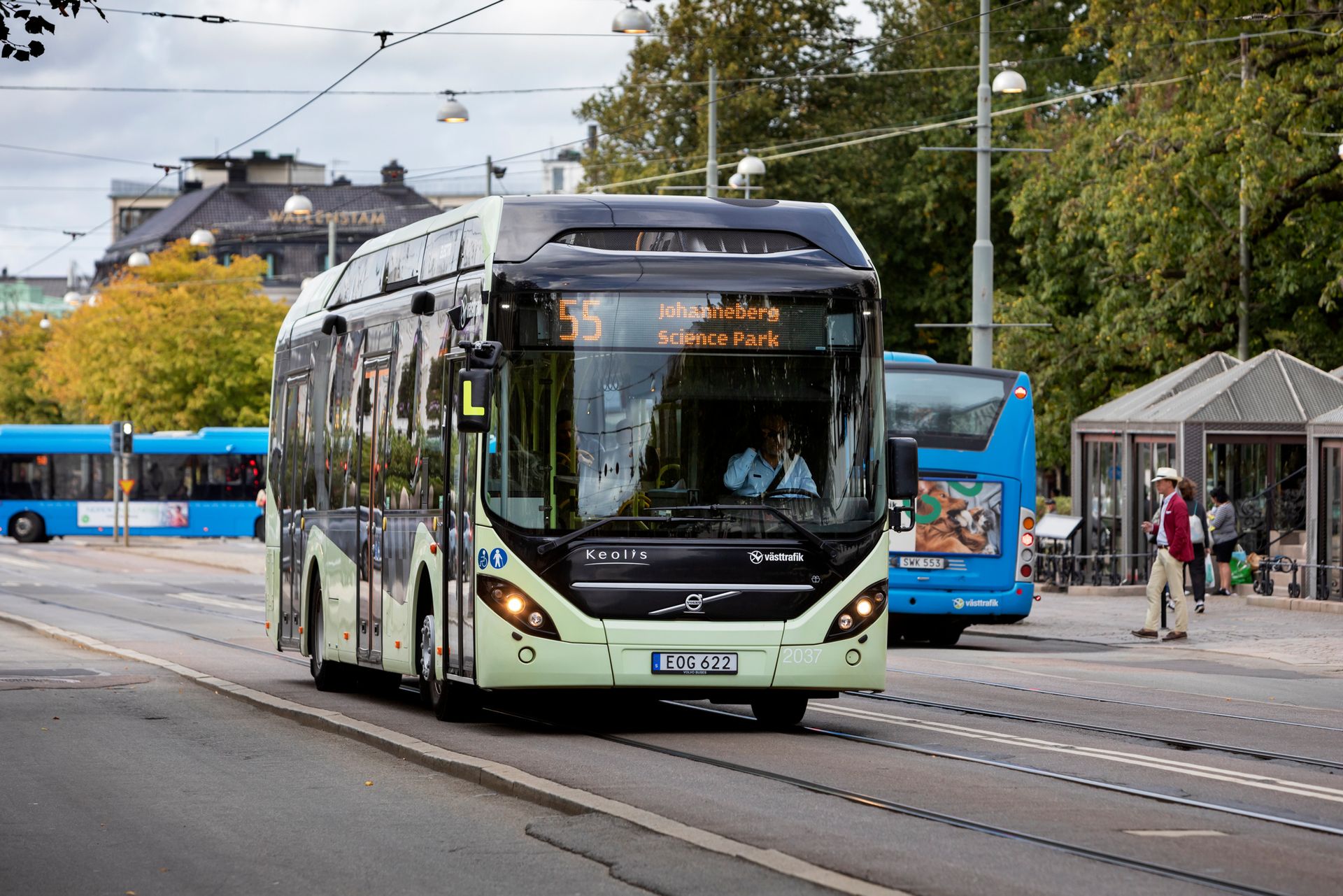 A modern electric bus driving down a street in Sweden.