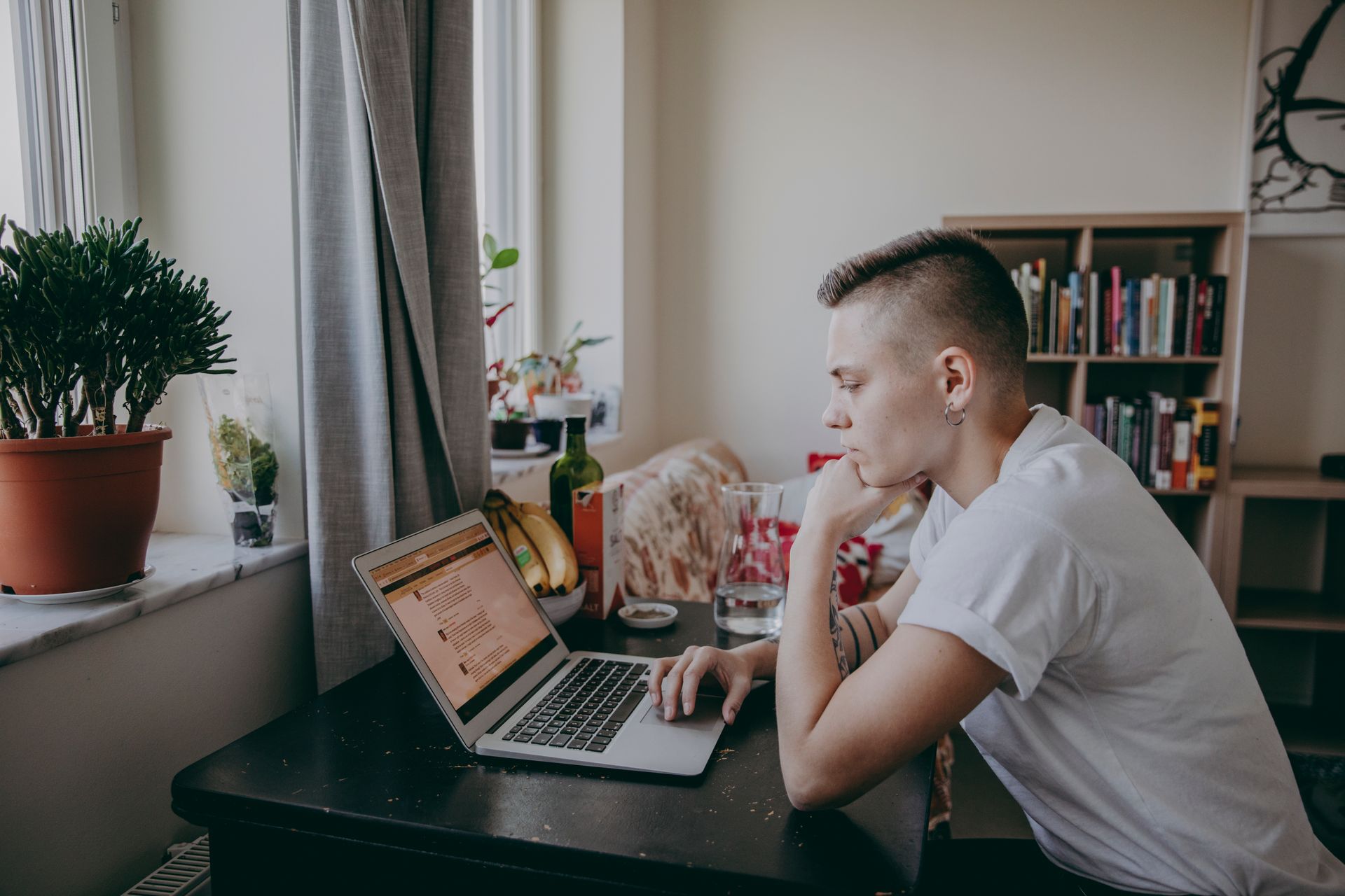 A young woman sits in front of a laptop.