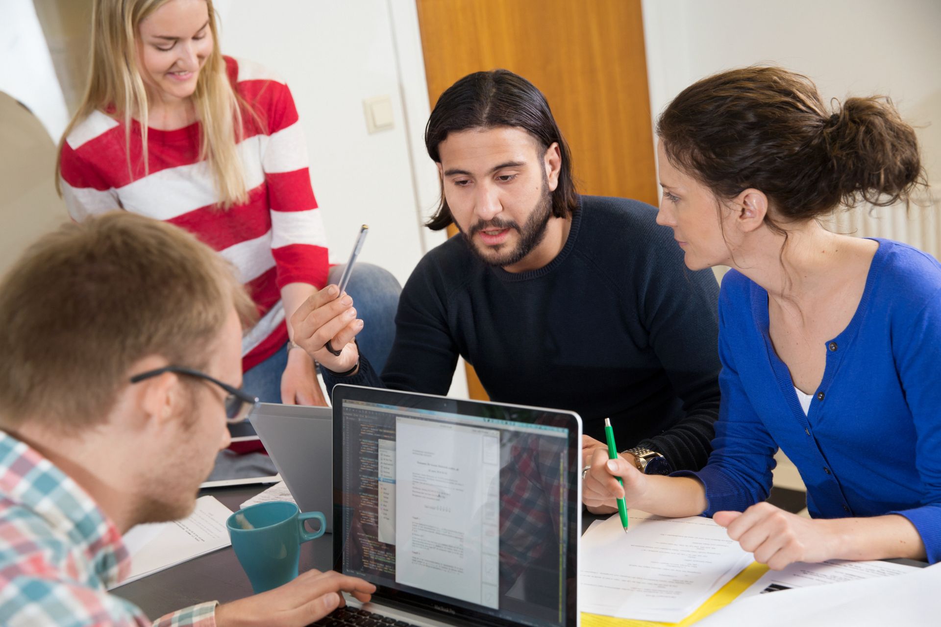 A group of people engaged in a focused group discussion in a studious environment.