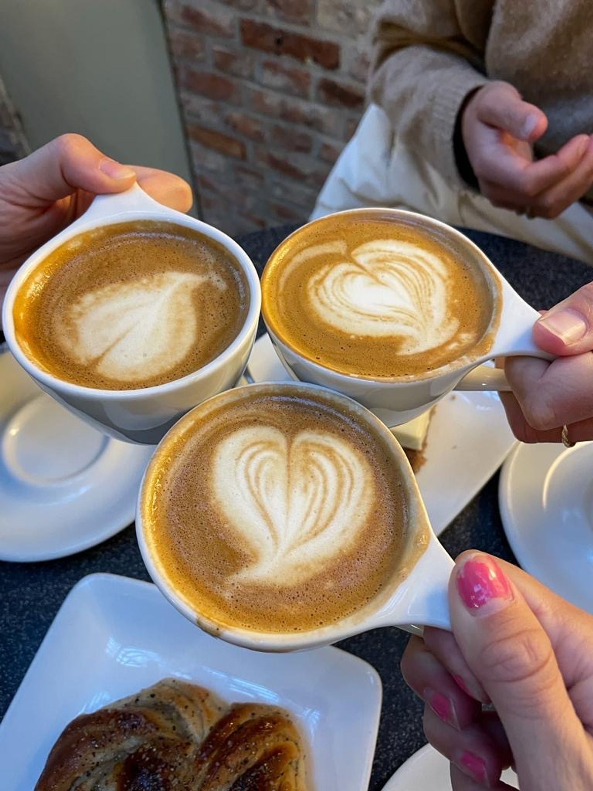 Three cappucinos with heart-shaped latte art.