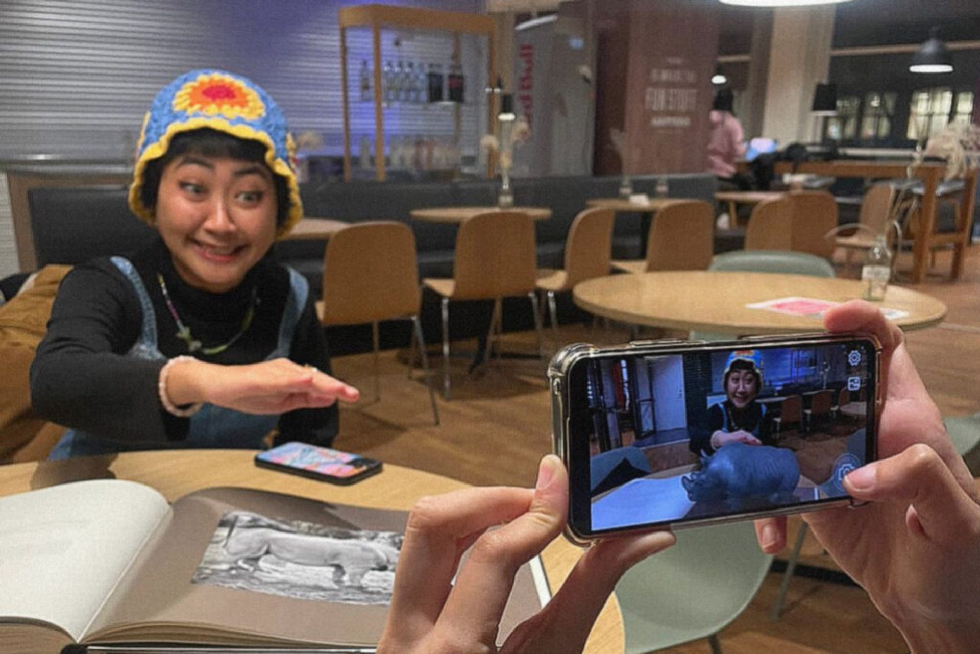 An international student playing with VR while wearing a colourful knitted hat.