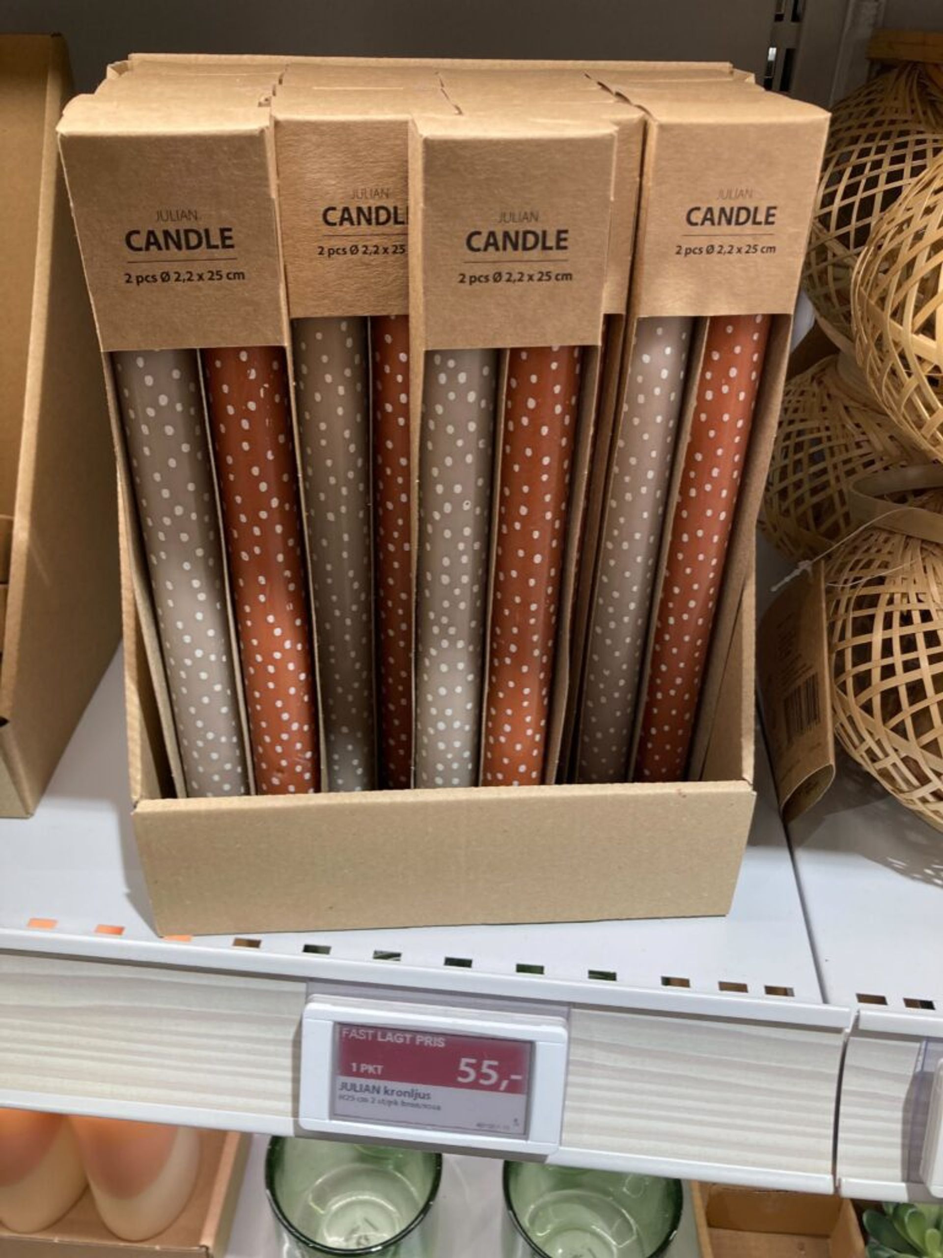 Packages of polka-dotted candles are displayed for sale on a store shelf.