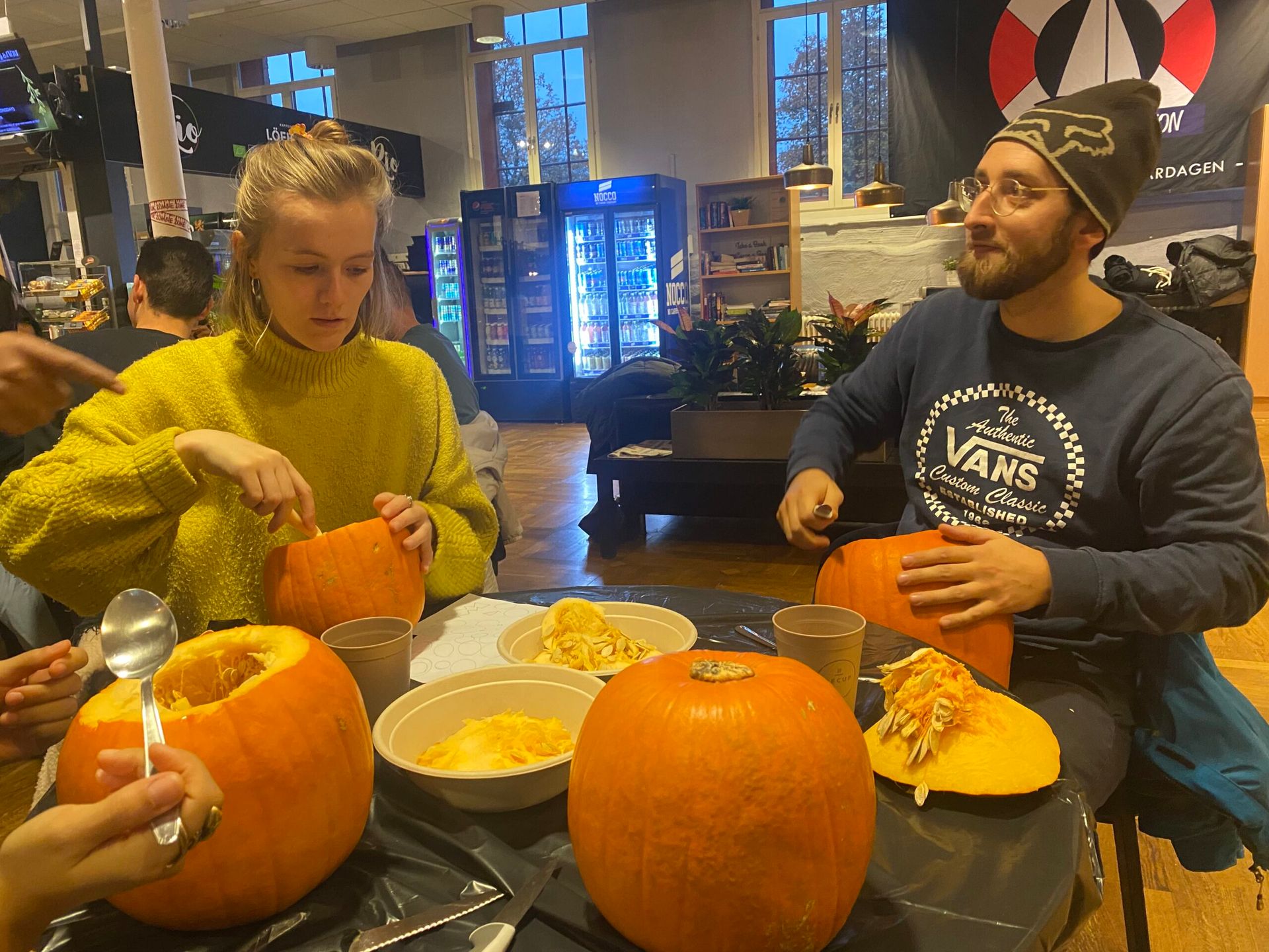 Students participating in pumpkin carving at a student café.