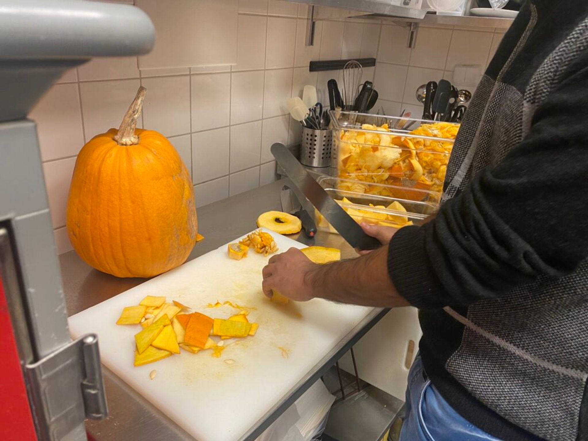 A close-up of a person cutting up pumpkin.