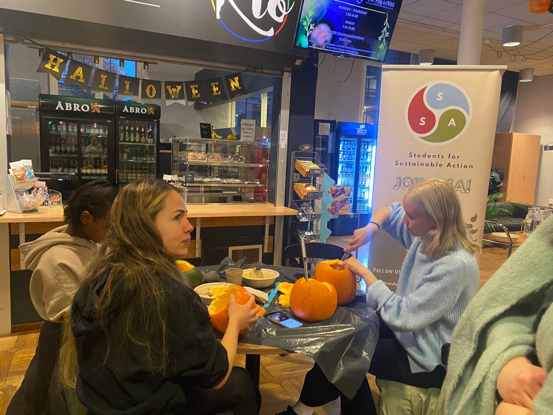 Students participating in pumpkin carving at a student café.