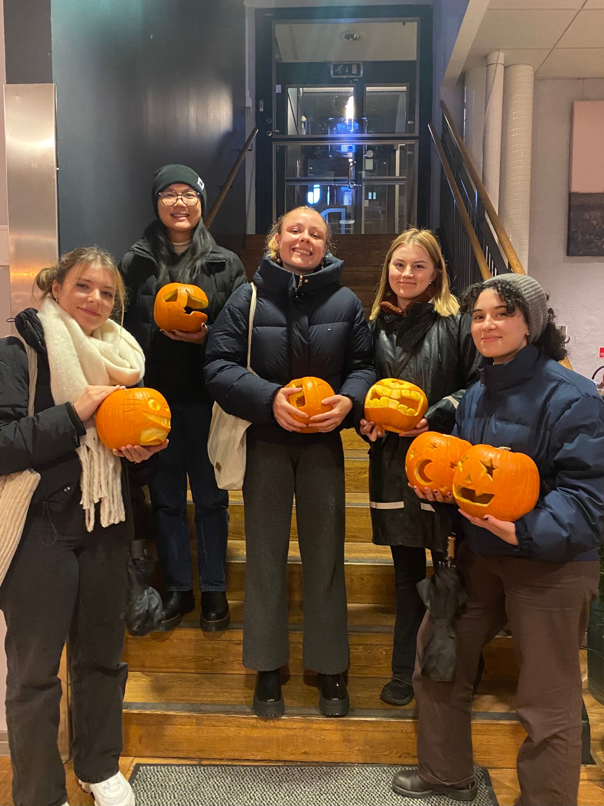 A group of people holding Jack-O’-Lanterns for Halloween.