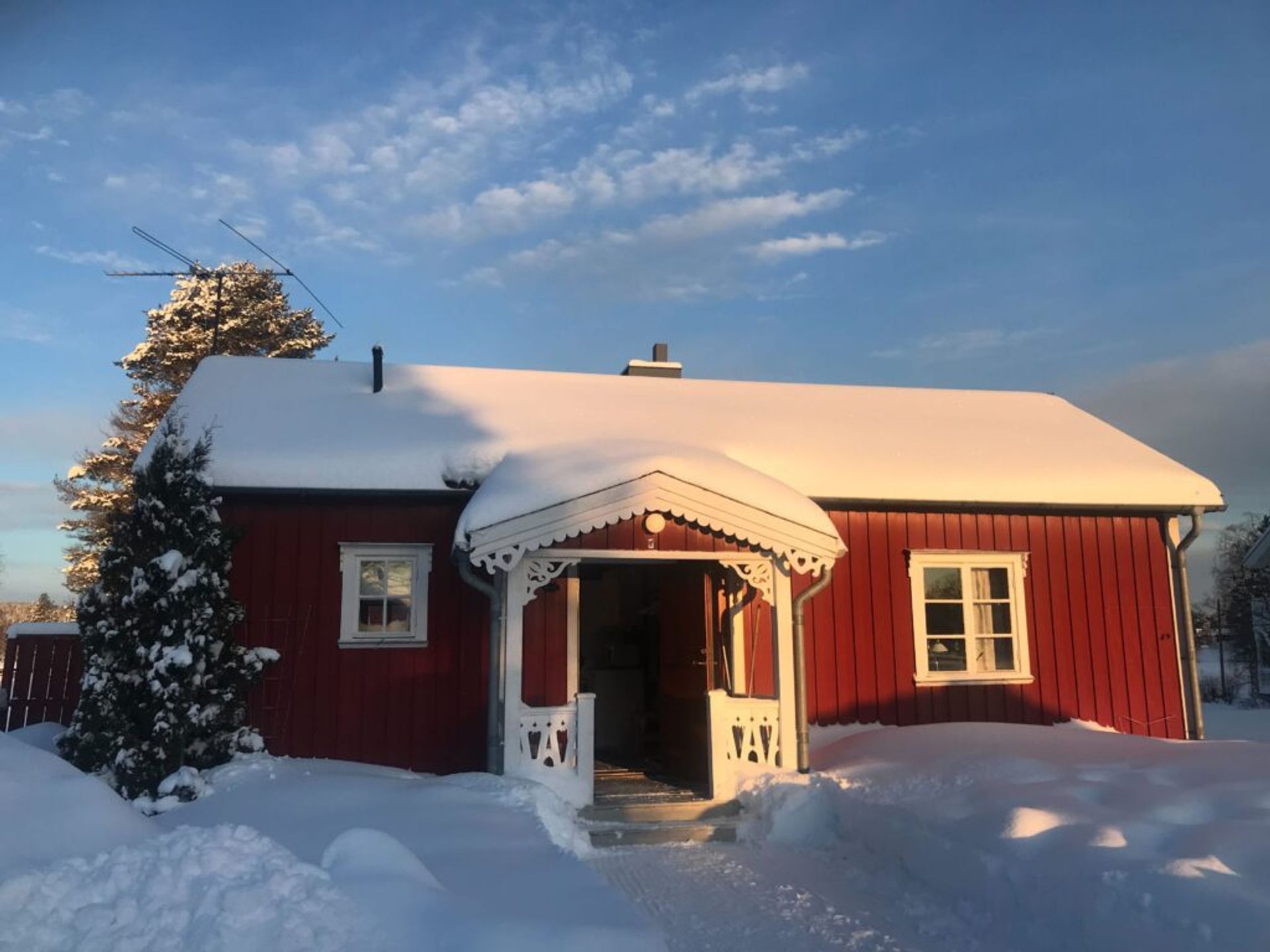 A red cottage covered in snow, located in Umeå, Sweden.