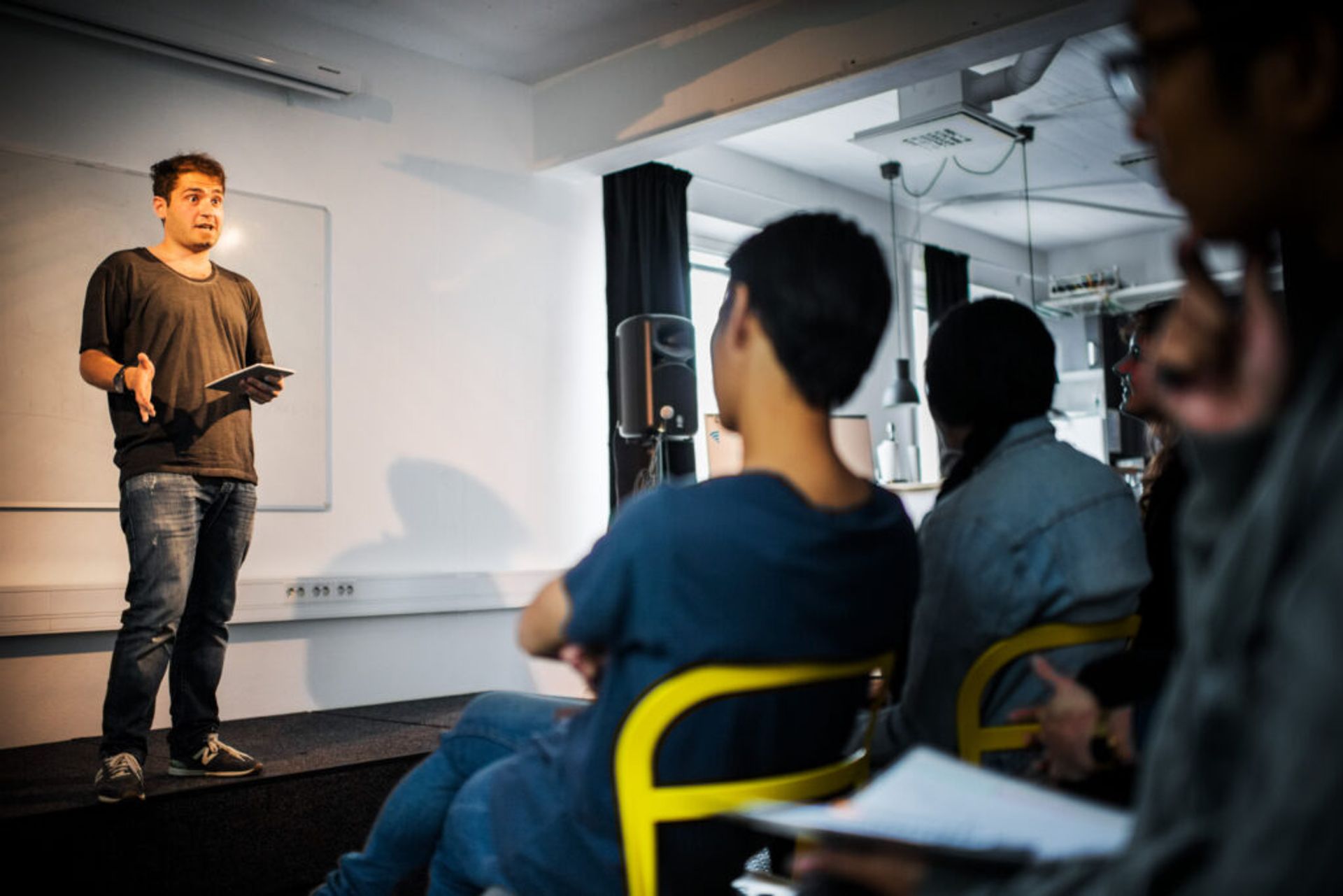 A person stands at engaging in academic opposition in front of a crowd of attentive listeners.