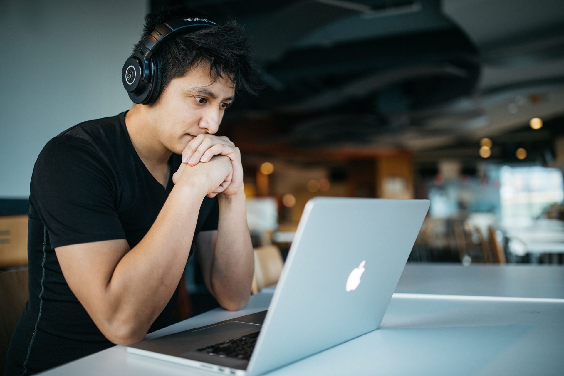 A person wearing headphones using a laptop.