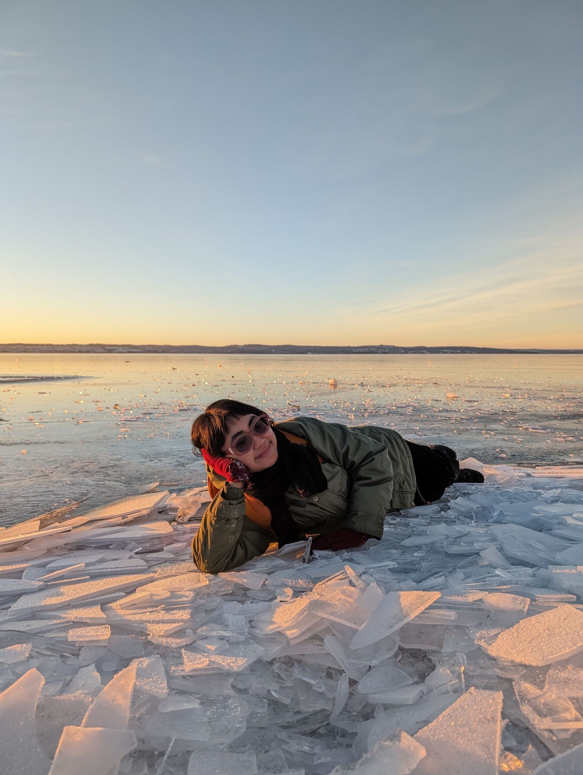 an international student having an extraordinary experience laying on a frozen lake