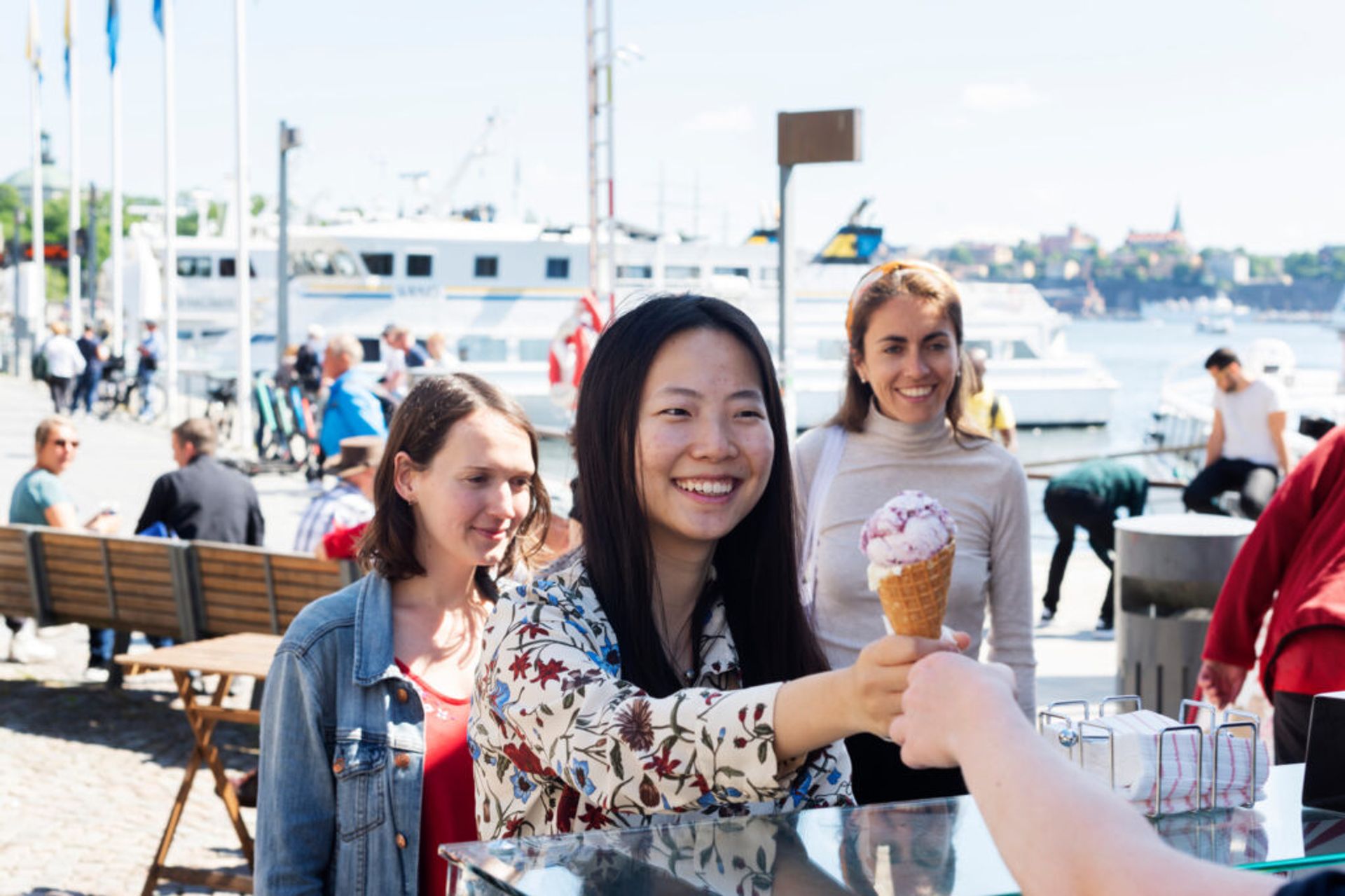 international students looking happy in a harbour in Stockholm, buying ice cream