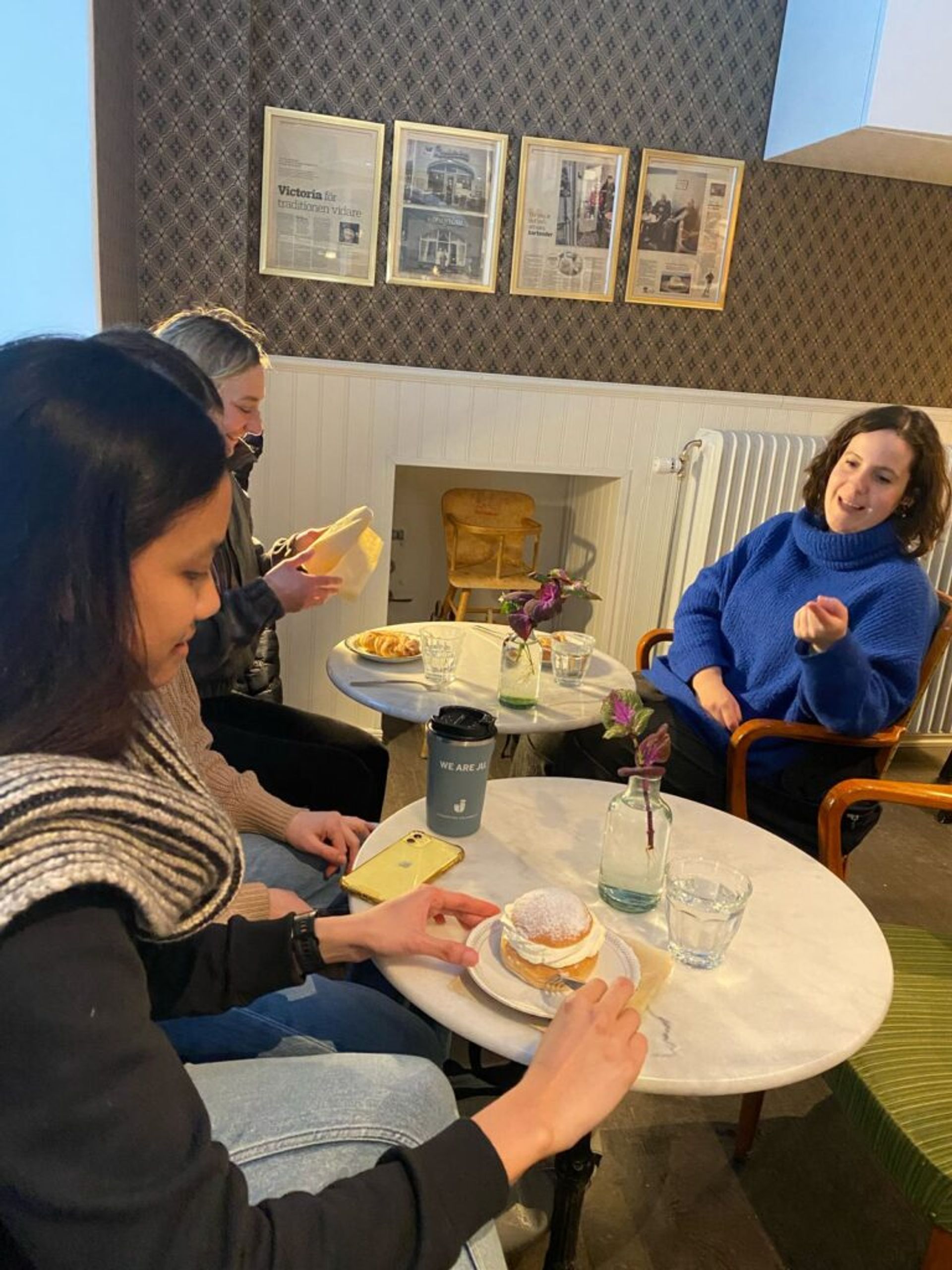 Several international students in a konditori in Sweden with semla buns