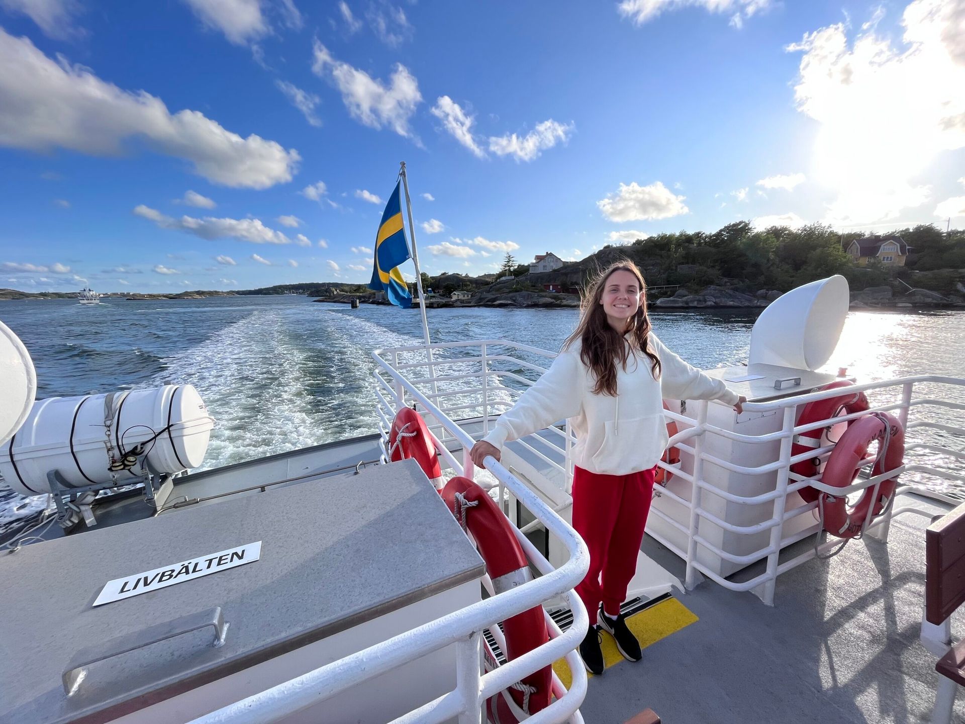 A woman happily smiling on a ferry boat.