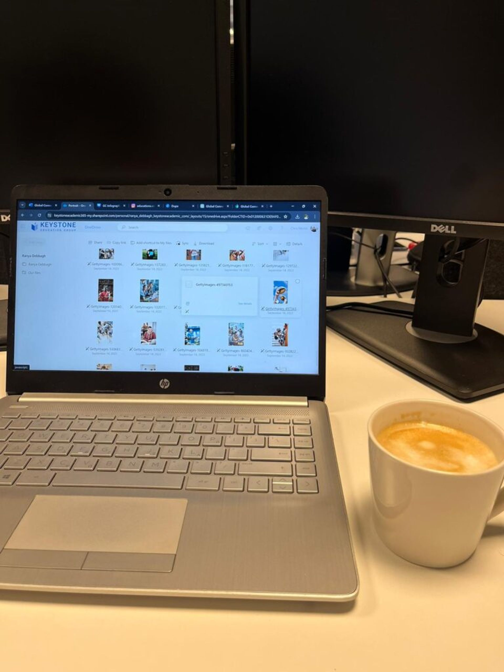 an international student working on his internship work on his laptop, with coffee on the side