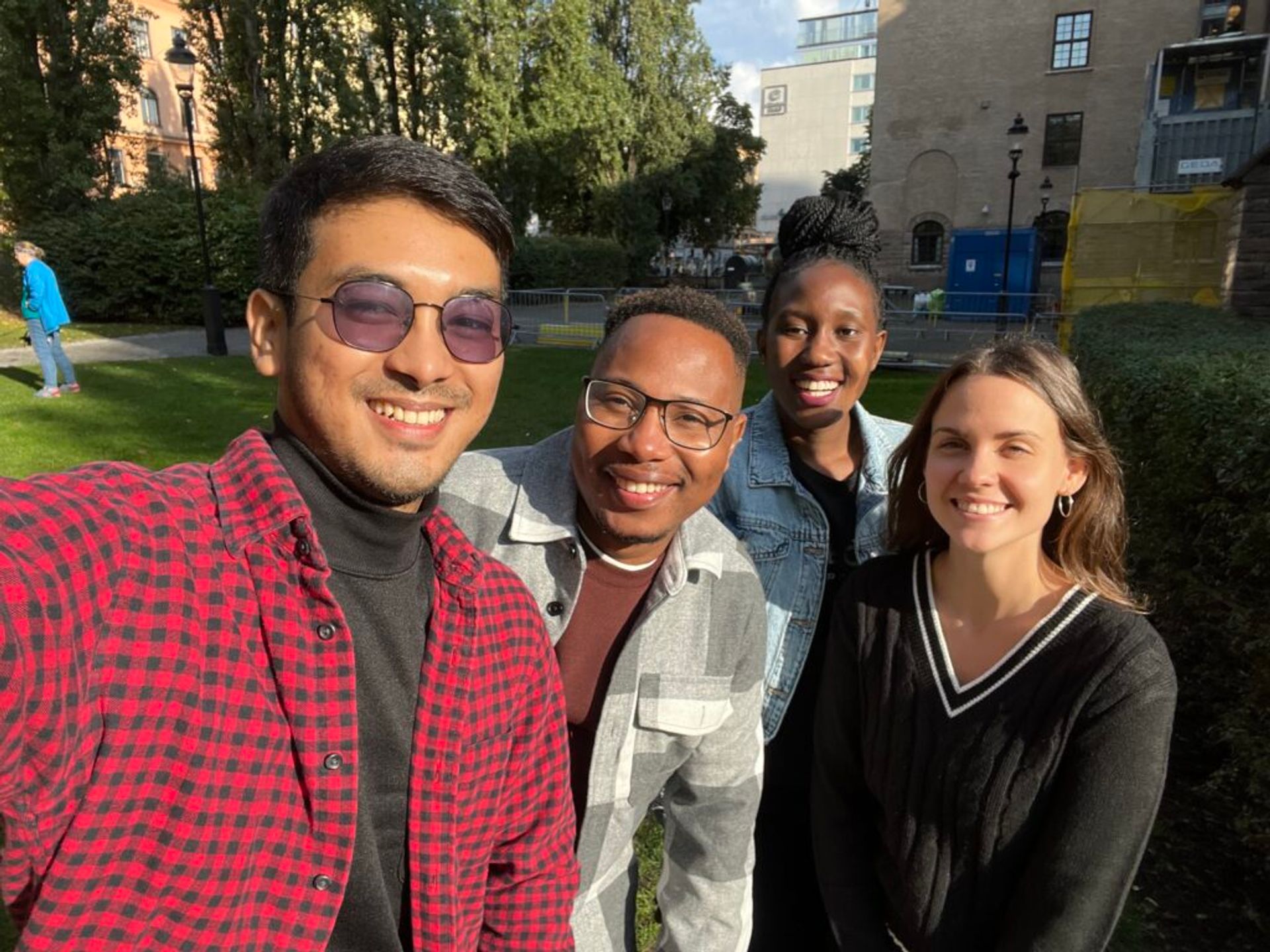 Four people of different nationalities taking a selfie.