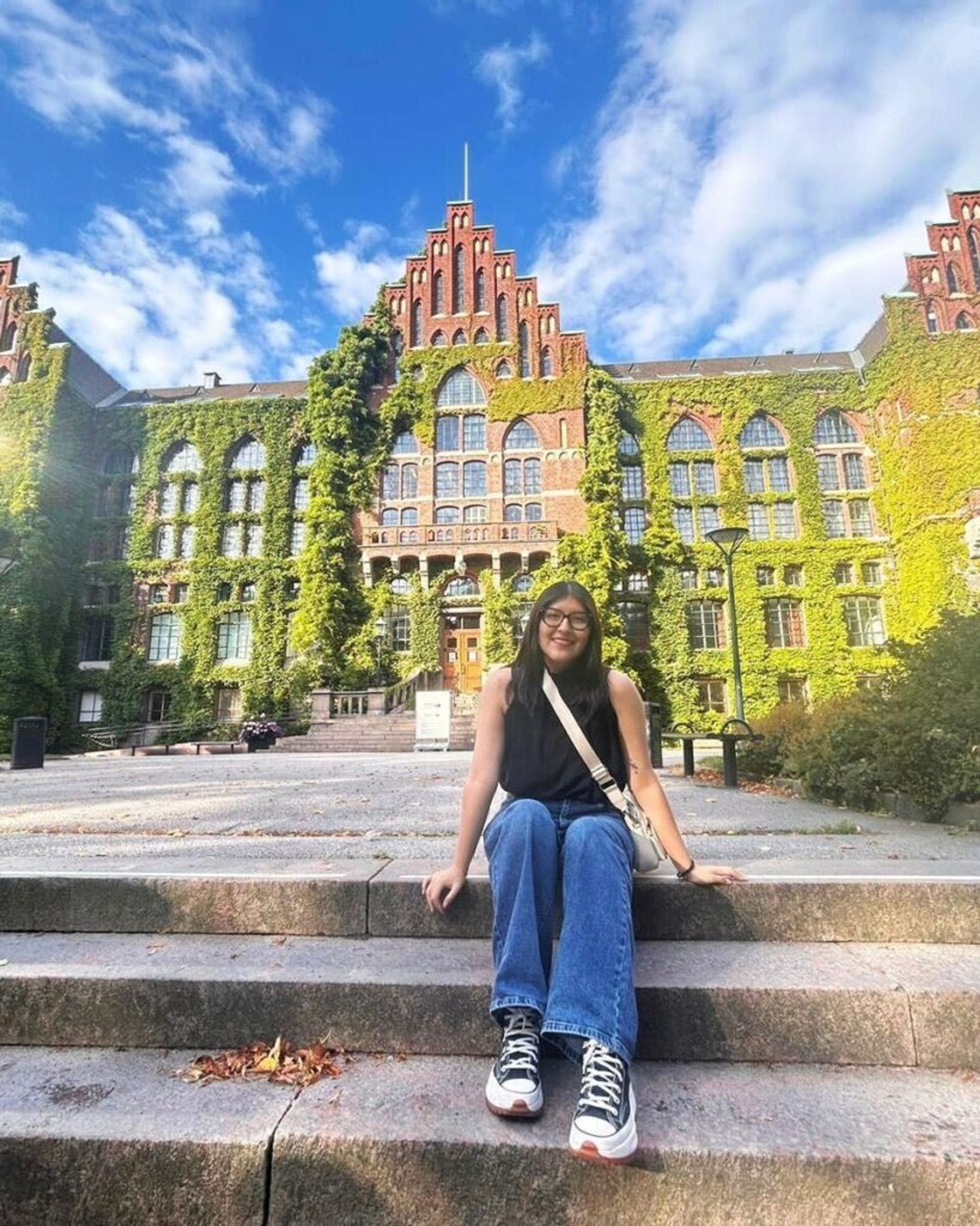 A girl posing in front of Lund University building.