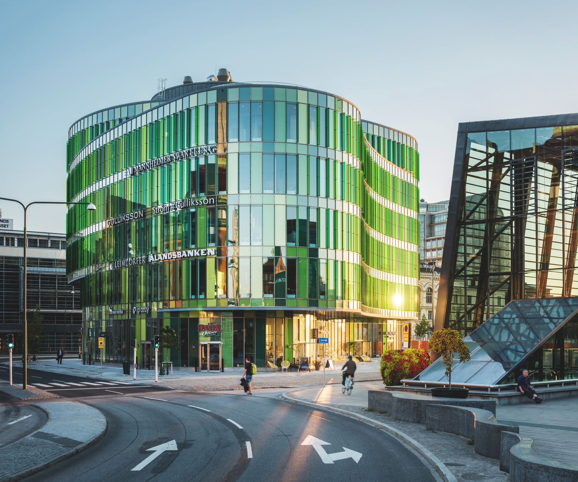 A green glass building in a city setting.