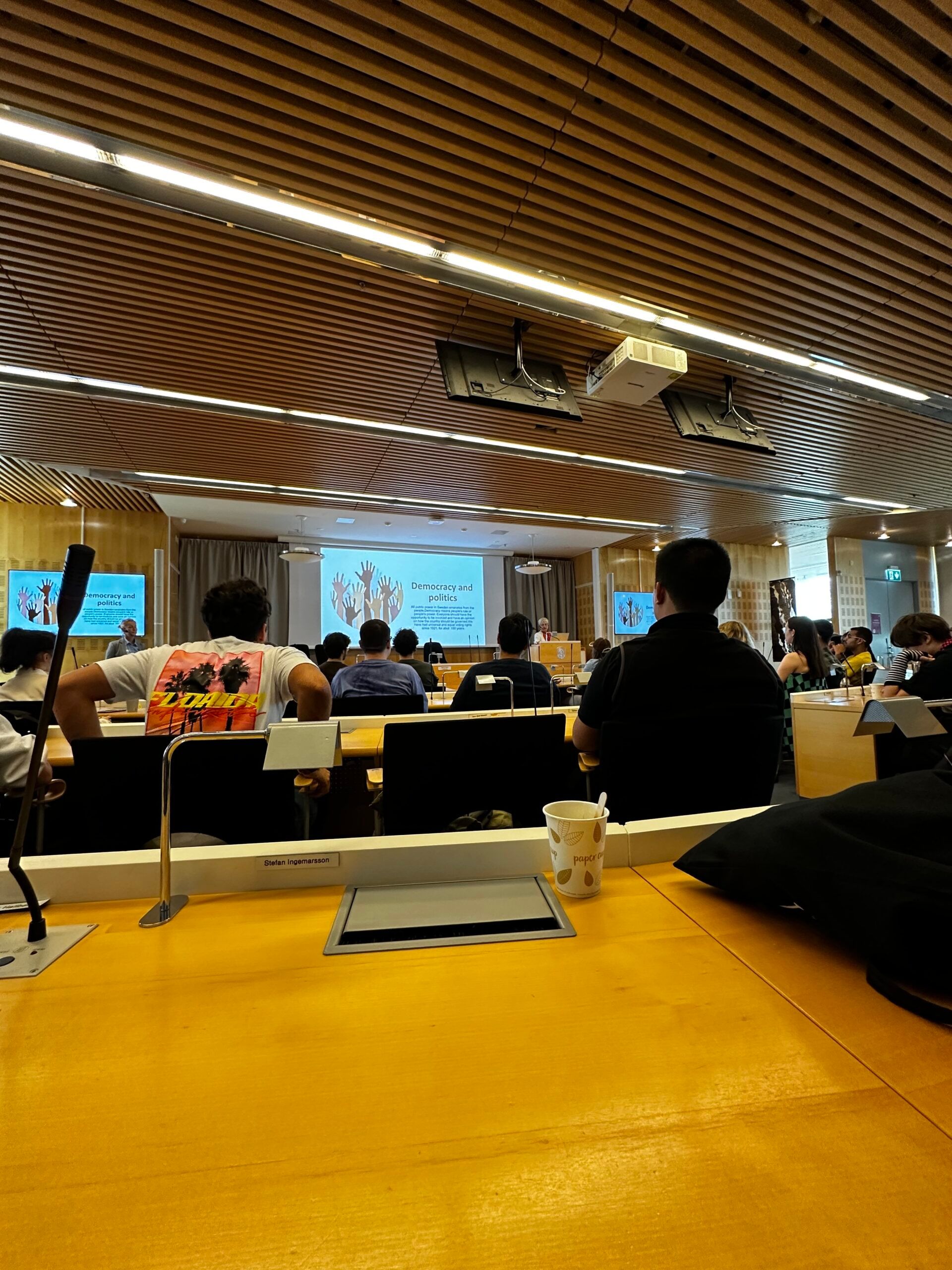 an interior of a lecture hall filled with students