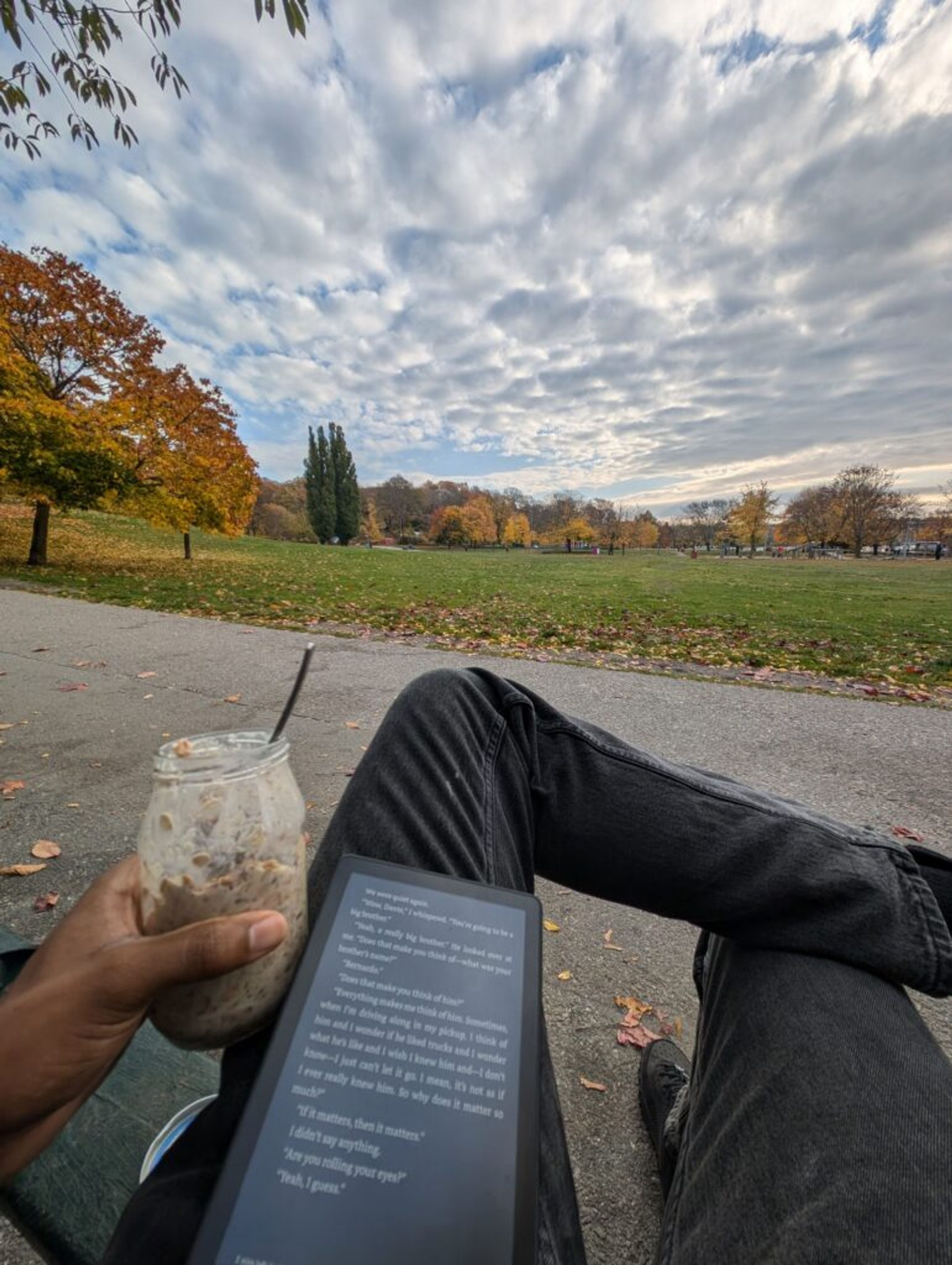 Joshua reading in the park in the autumn in his free time