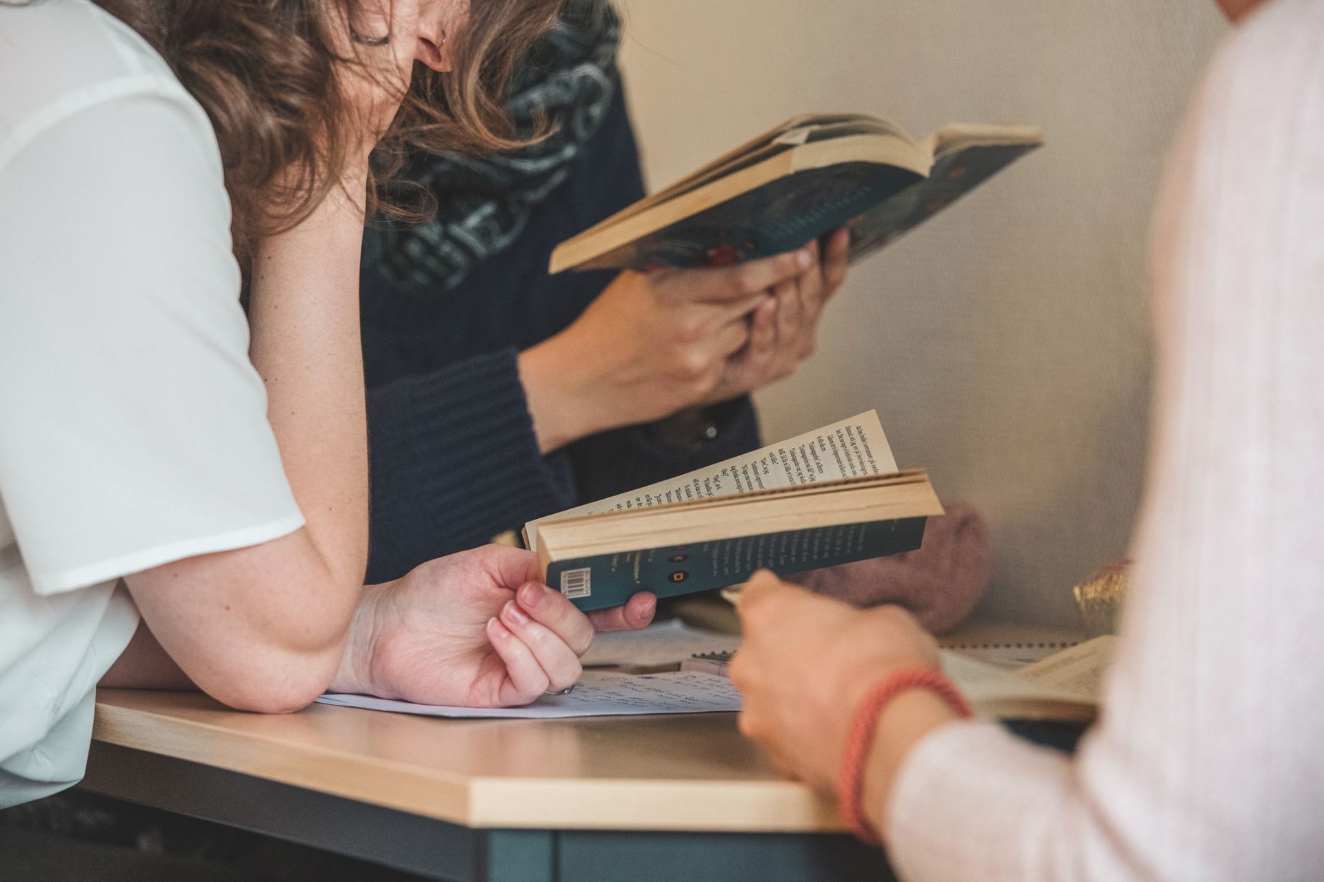 Students sitting around a table with books.