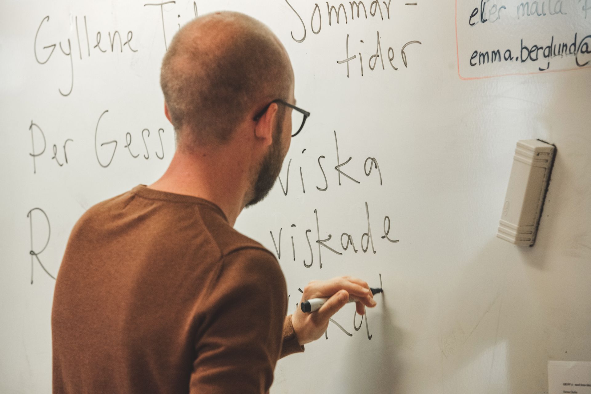 A man writing on a whiteboard.