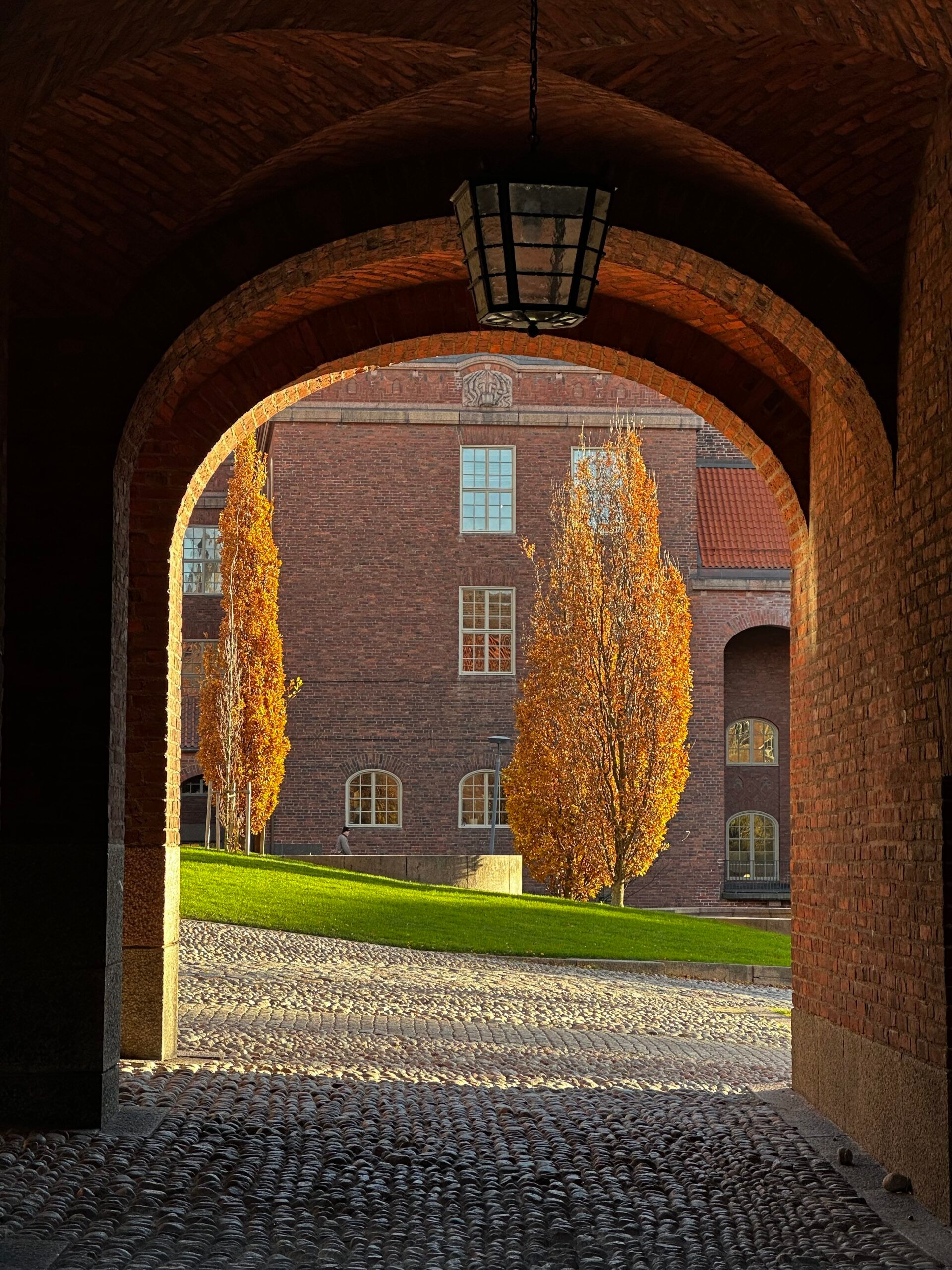 An exterior shot through a brick tunnel revealing a courtyard