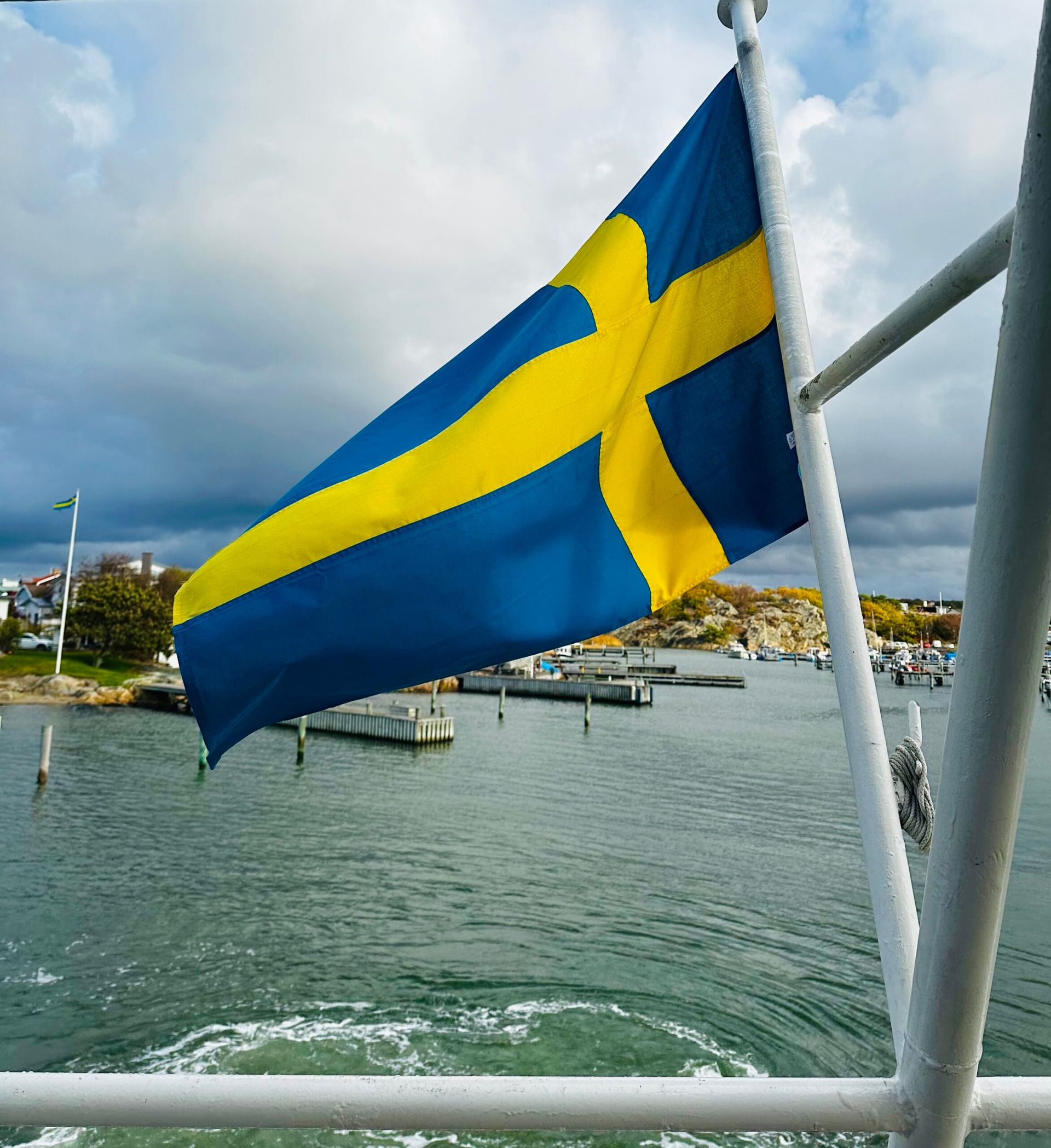 The Swedish flag waving with the sea behind