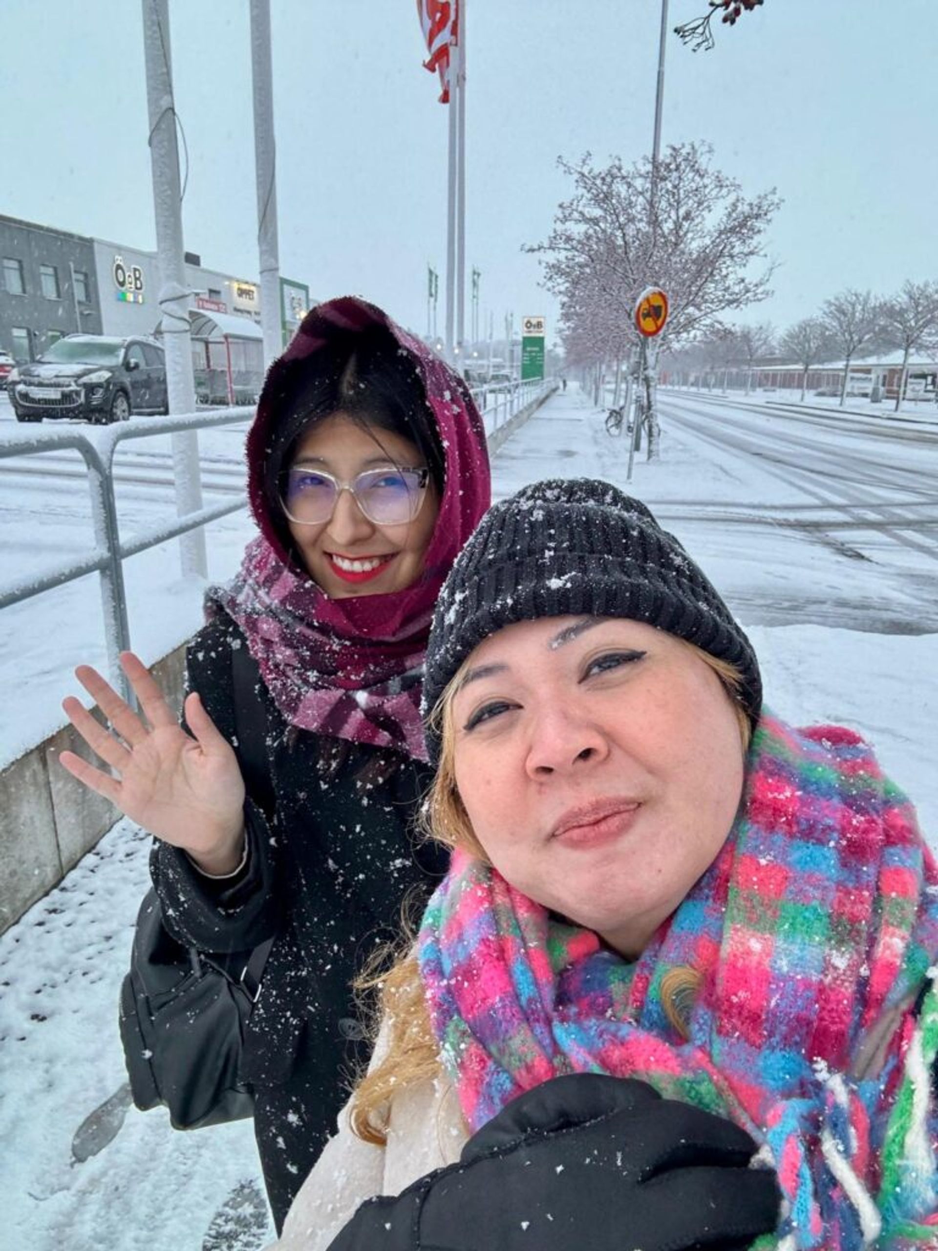 Two girls covered in snow smiling for the camera.