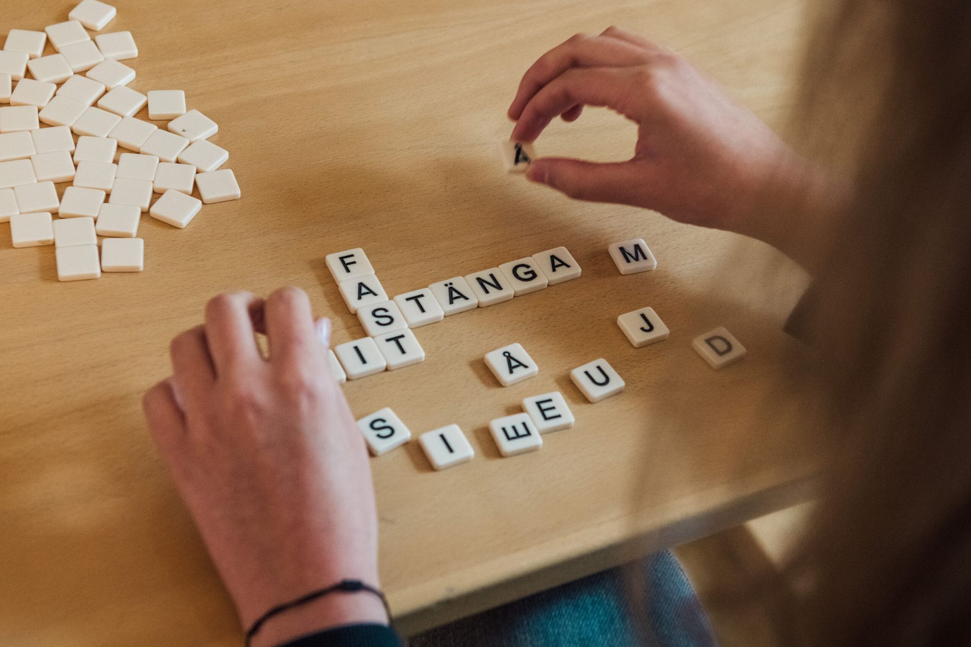 A woman making words from Scrabble letters