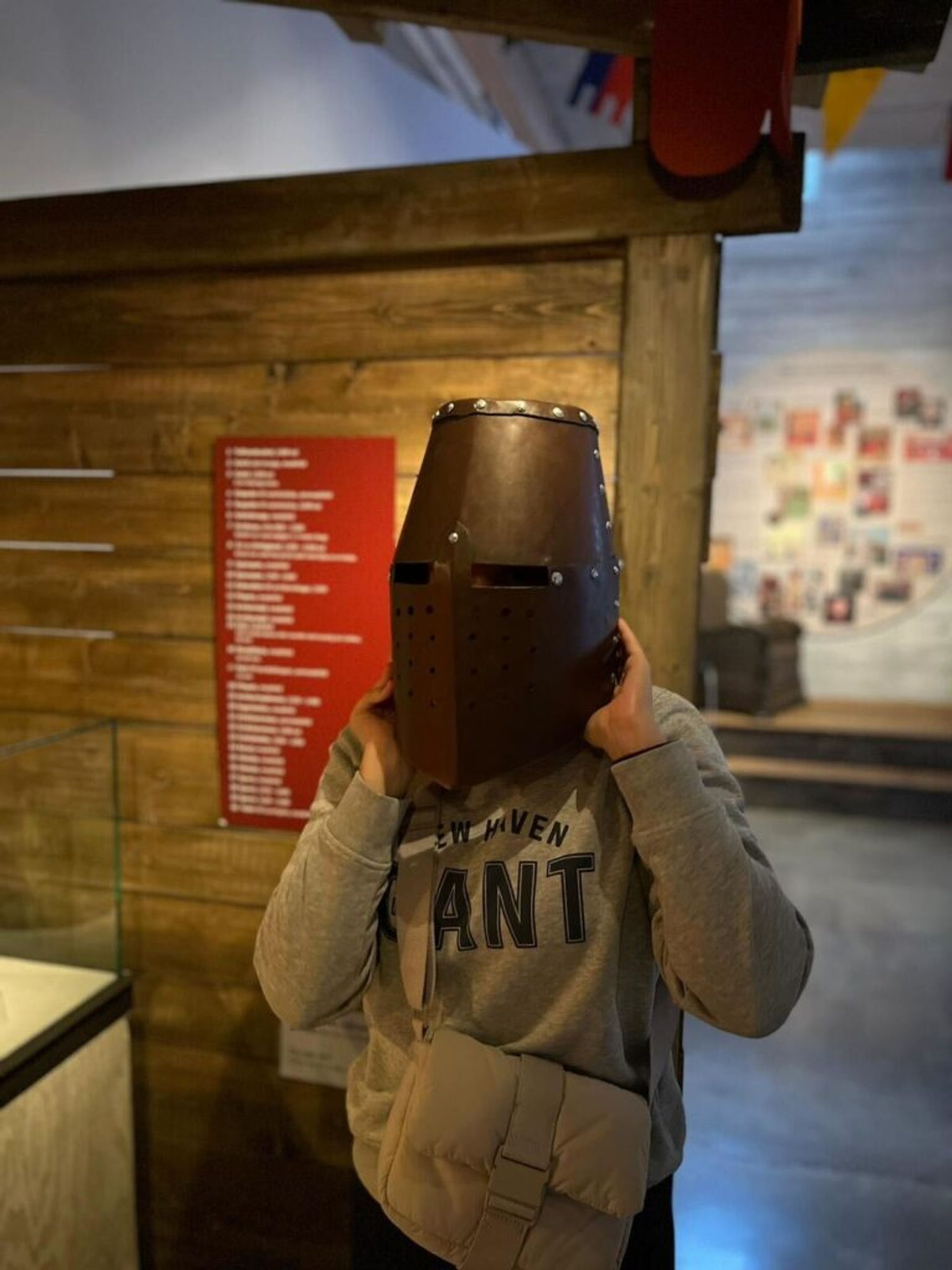 A girl wearing an ancient helmet replica.