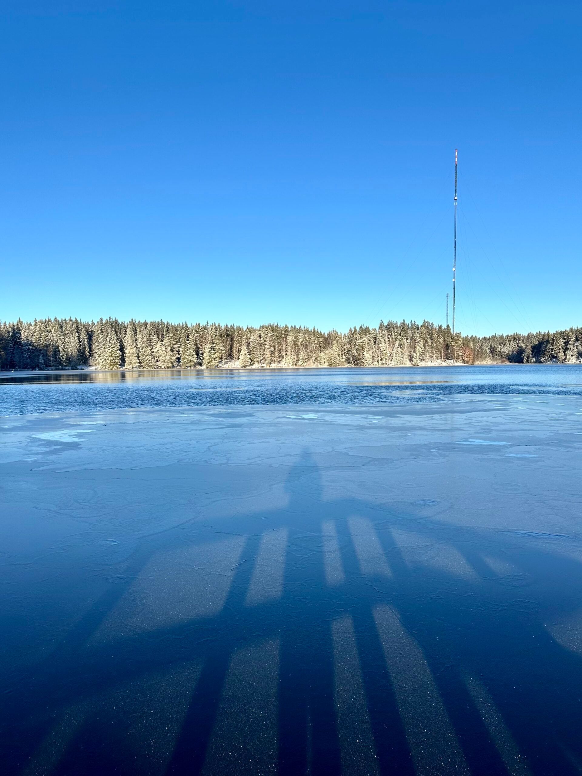 A frozen lake with the reflection of the photographer visible