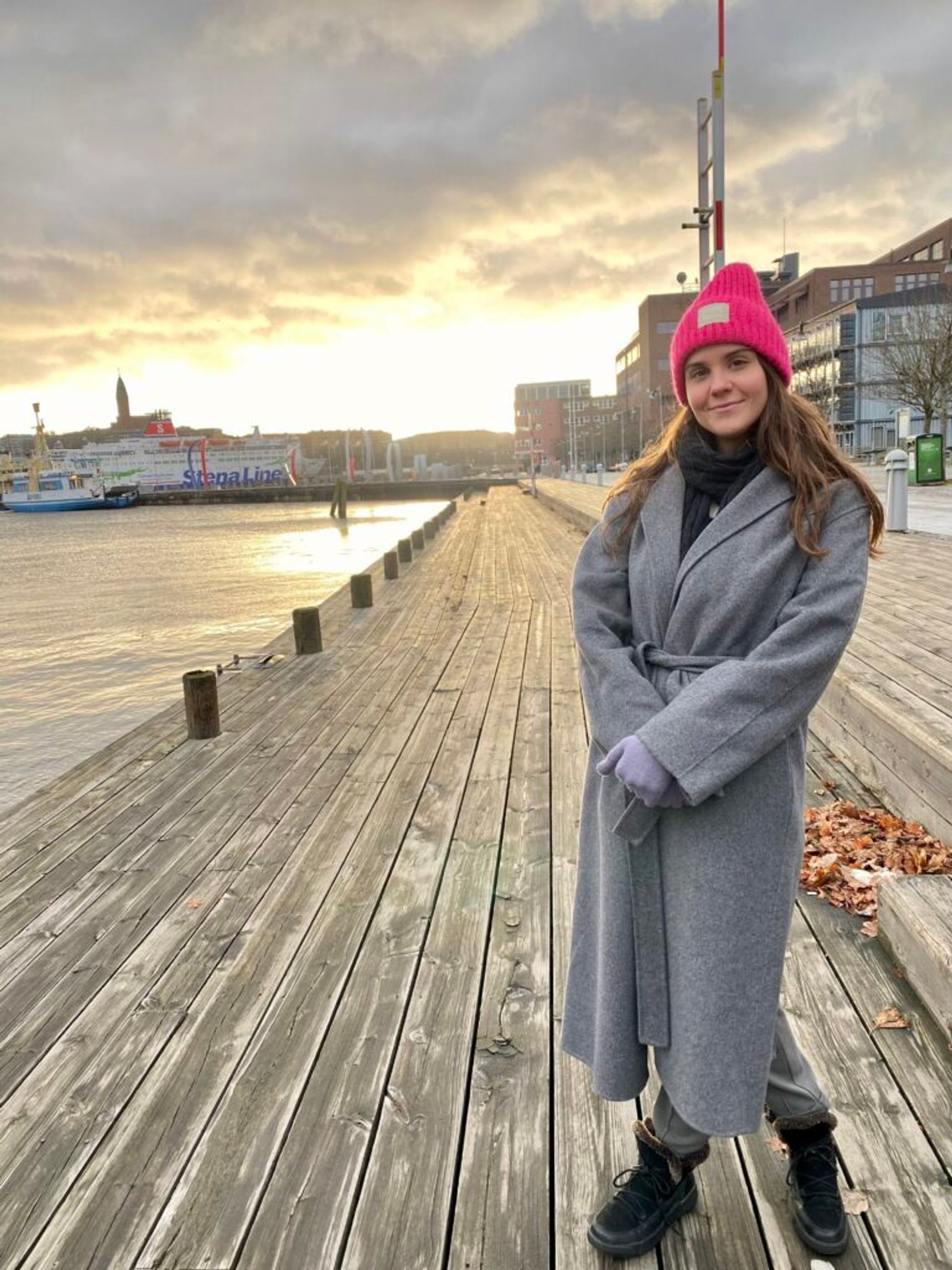 A girl in a coat smiling.