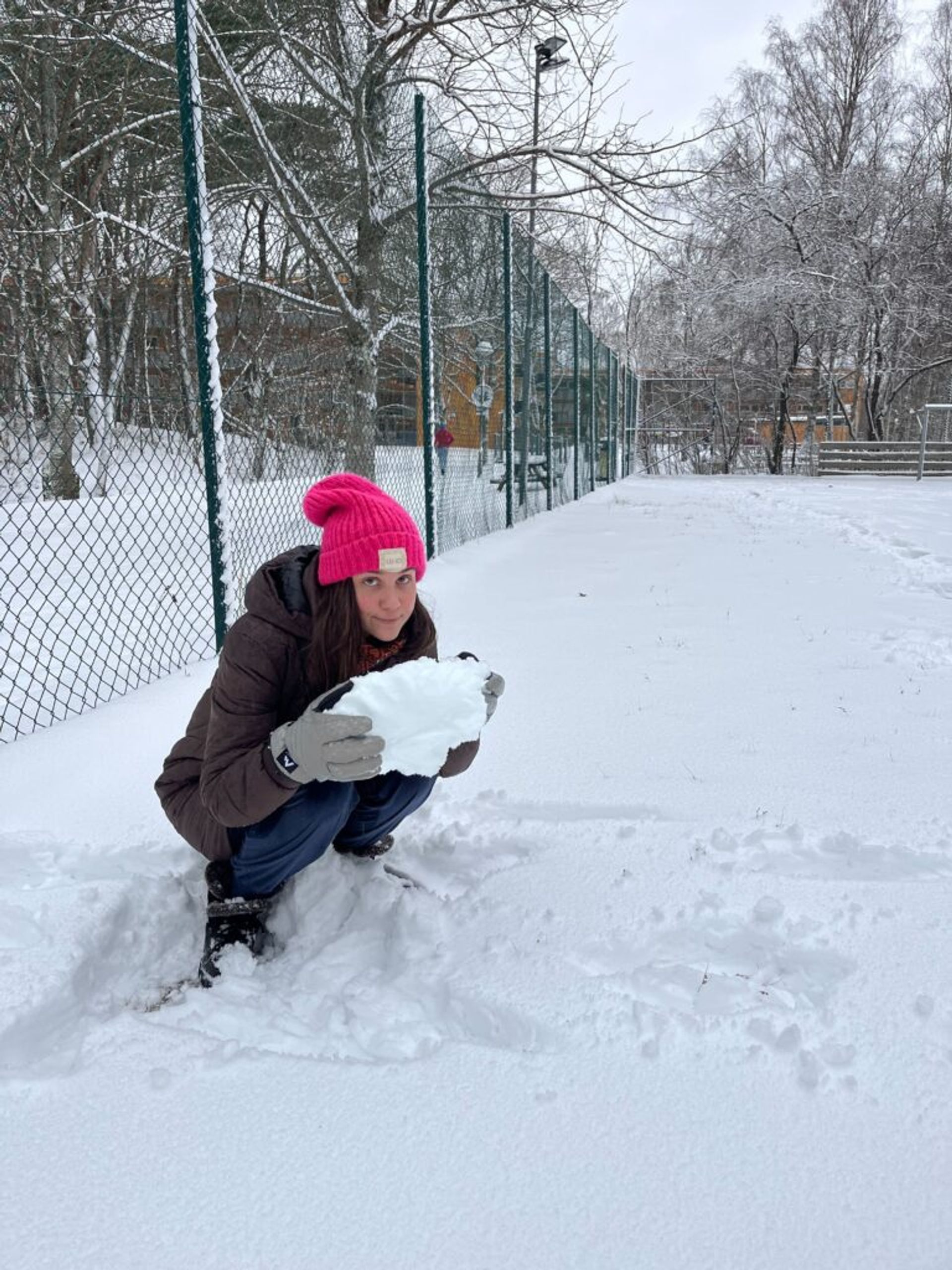 A girl holding a snowball. 