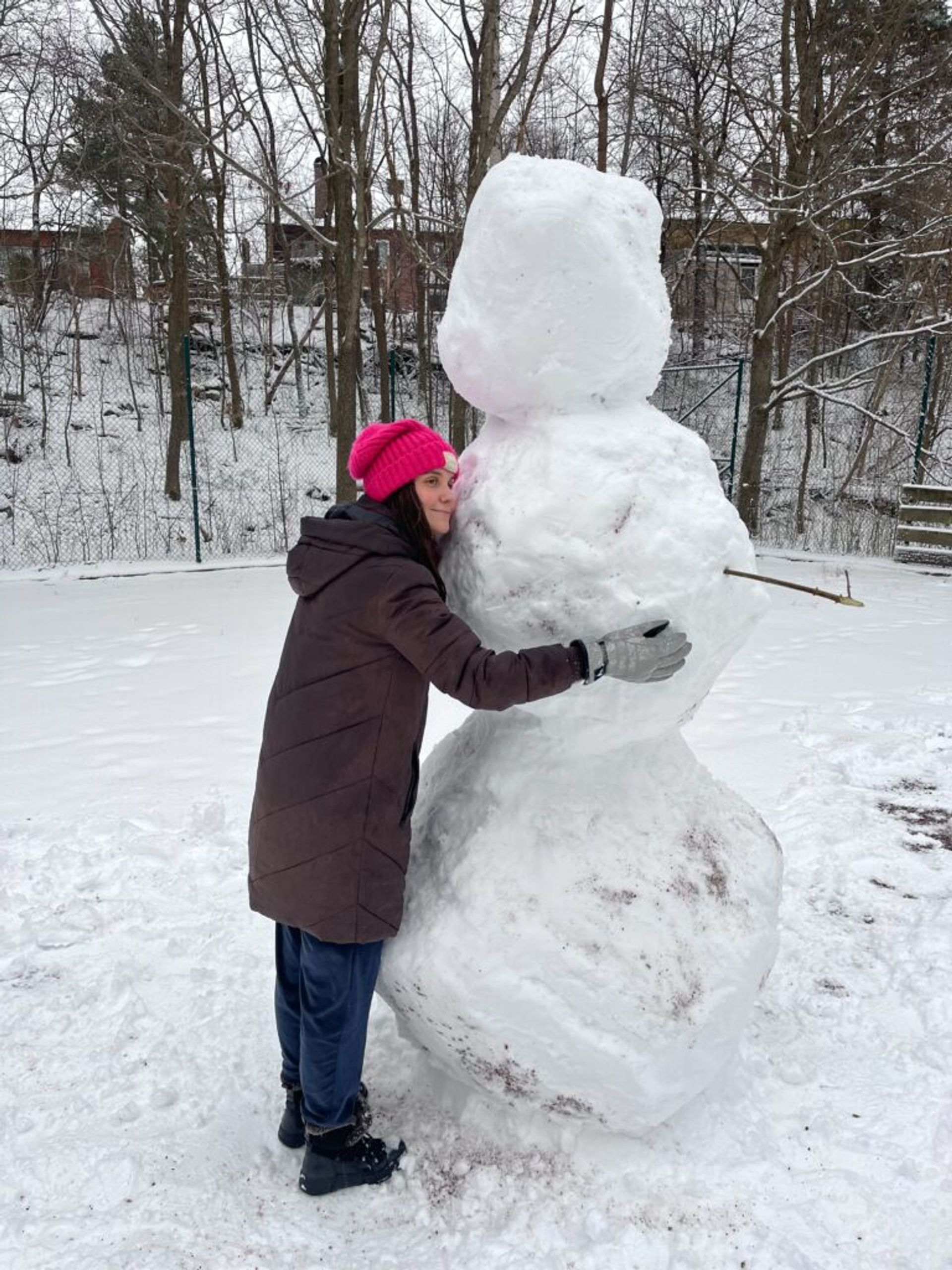 A girl hugging a large snowman