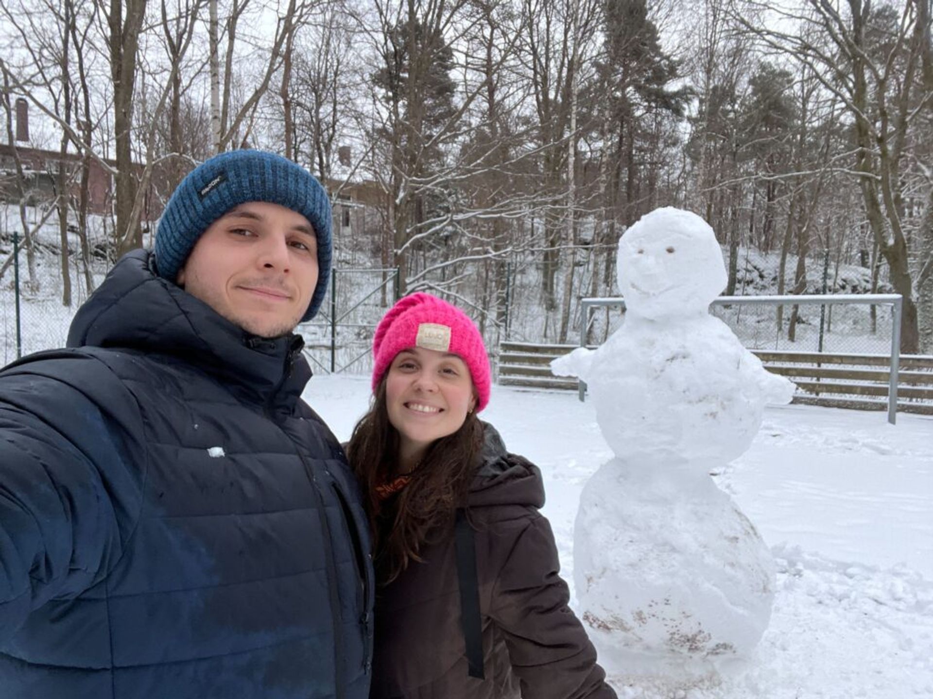 A couple taking a selfie with a snowman