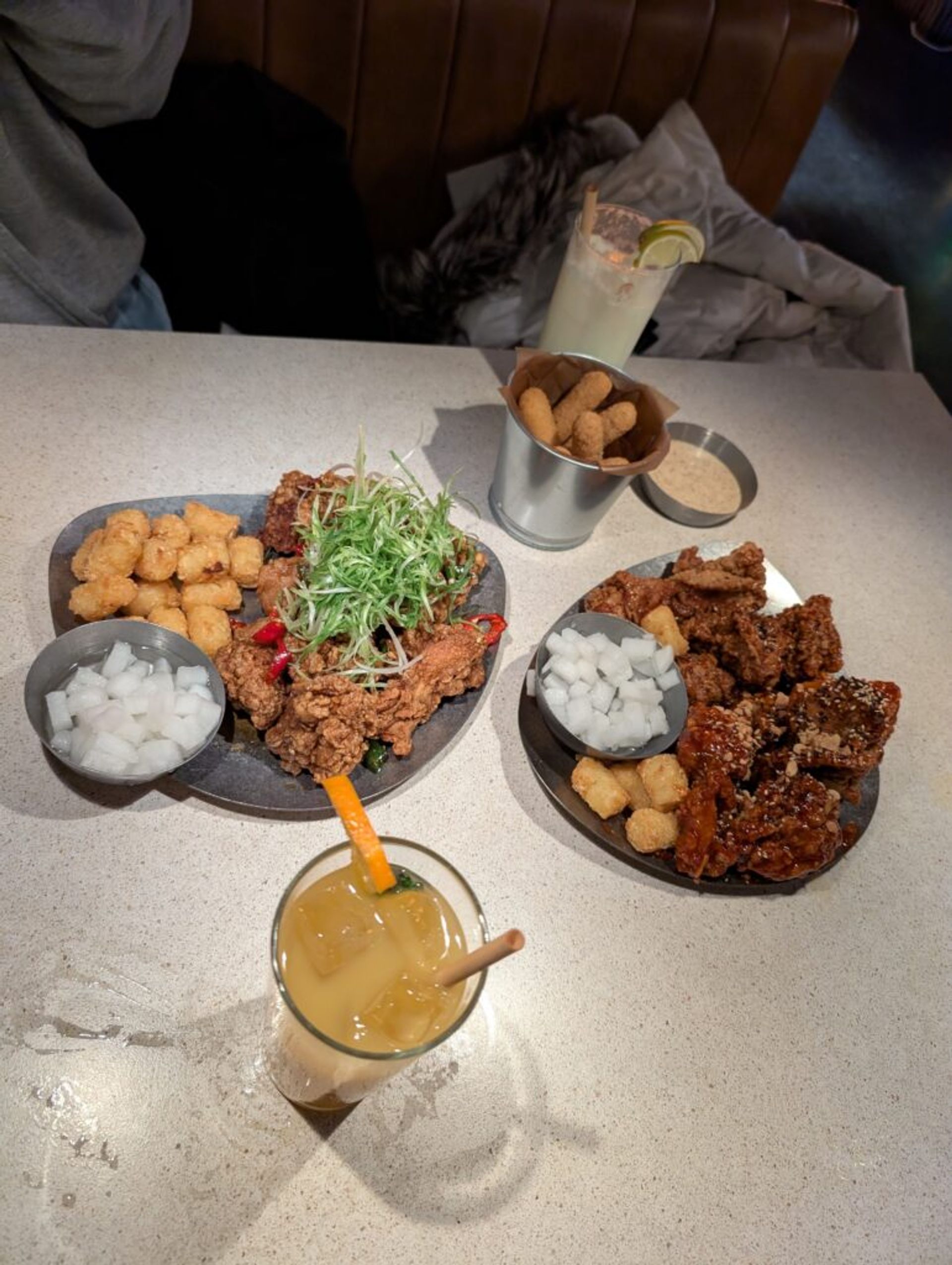 A picture of a table with fried chicken, mozzarella sticks and potatoes. 