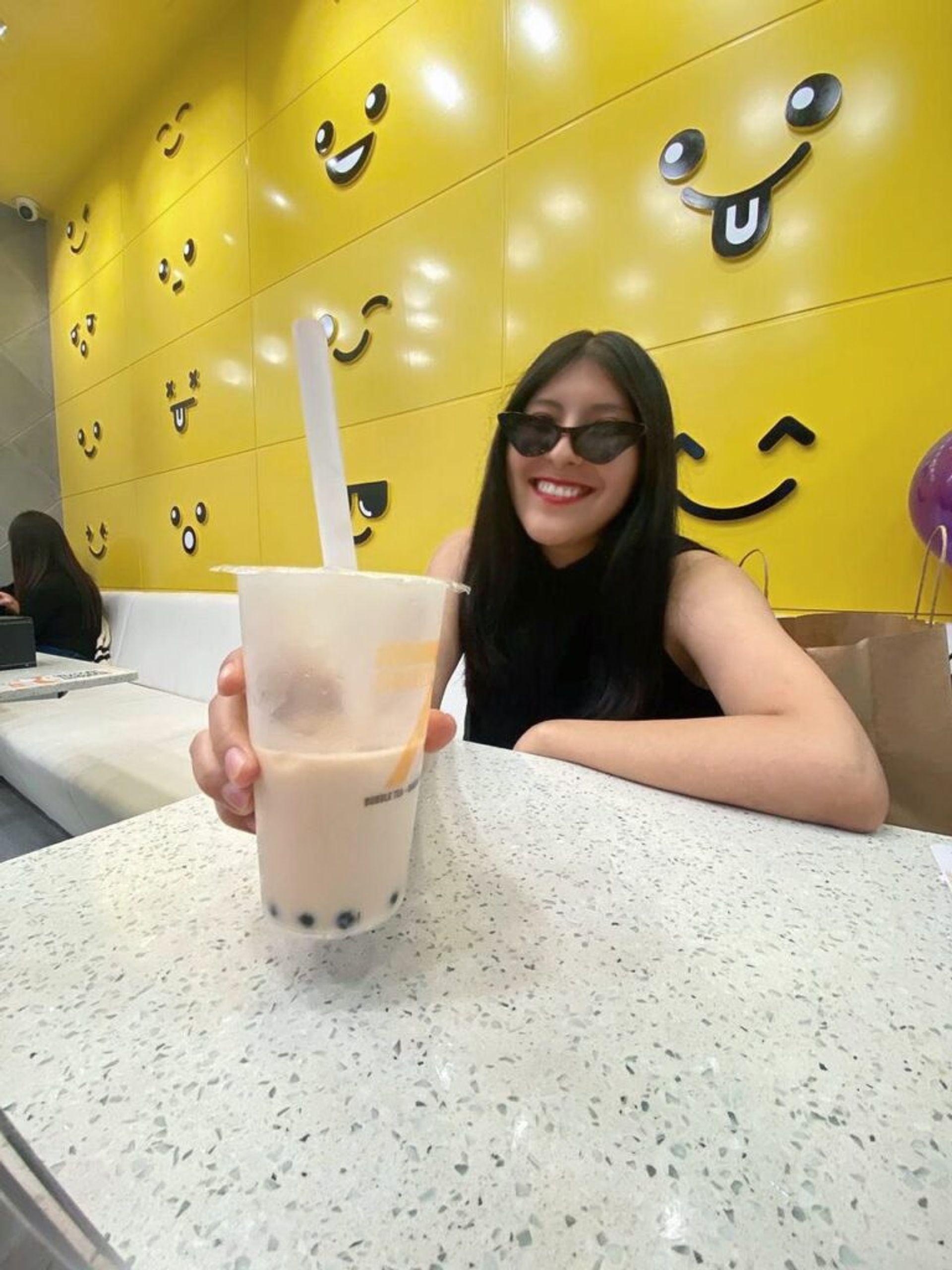 A happy girl showing a bubble tea drink