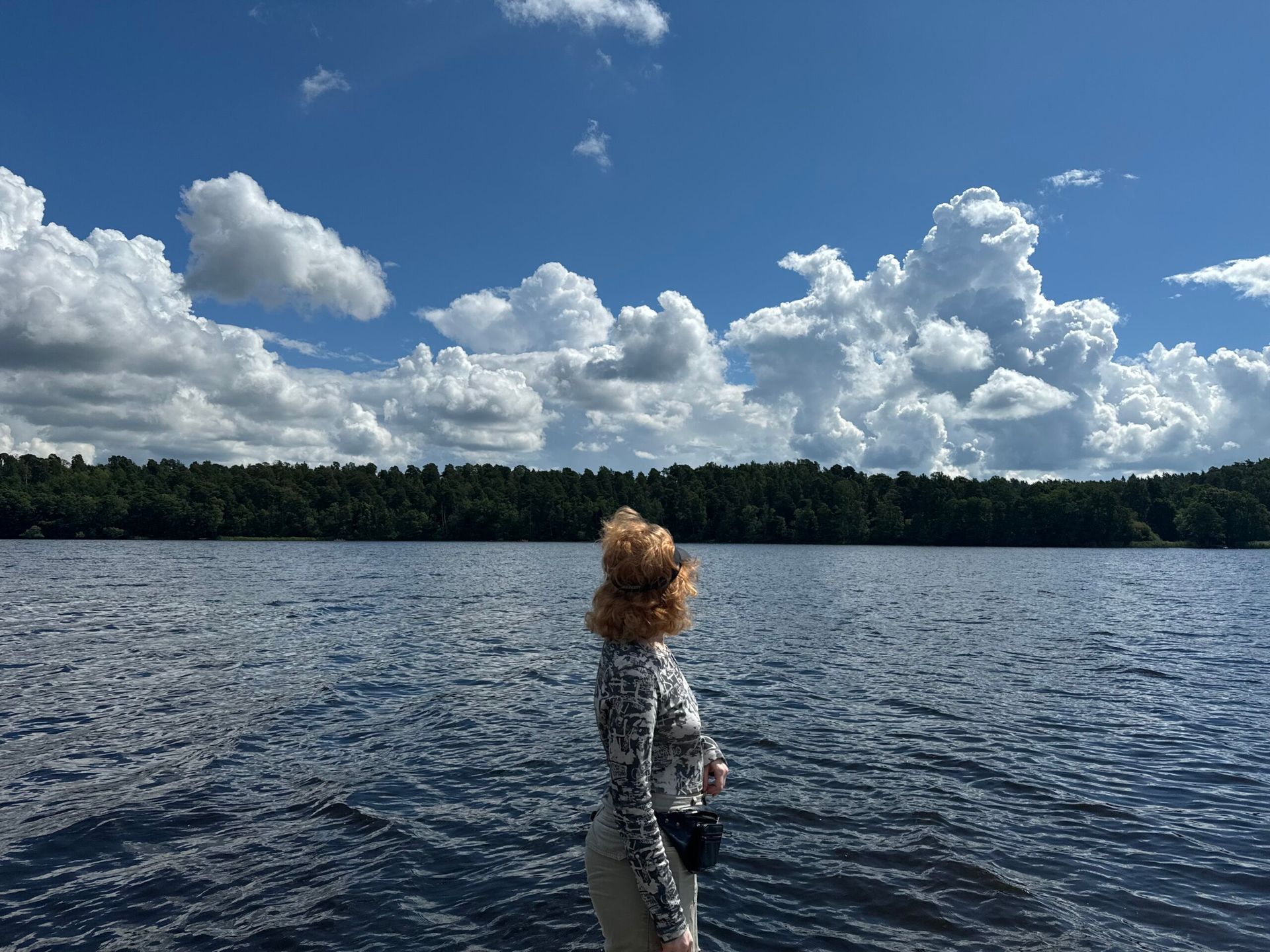 A girl standing with a lake backdrop